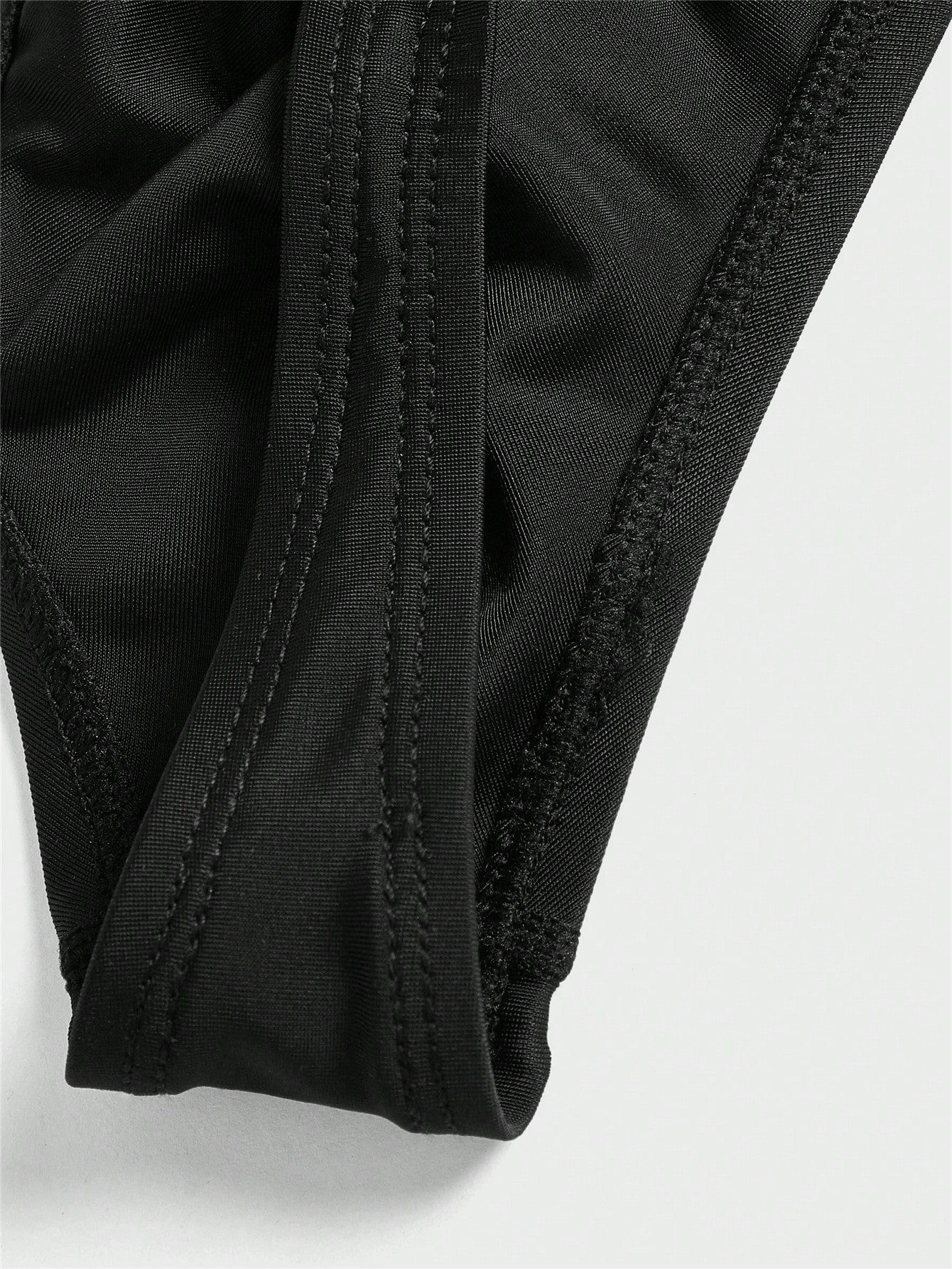 Black men's plain swim briefs with cut-out detail, high waist, short length, and high-stretch polyester elastane fabric.