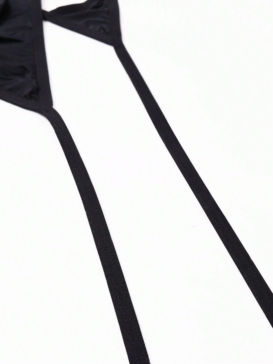 Men's black knitted fabric low-rise thong underwear featuring knot detail.
