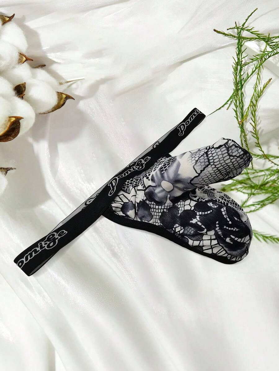Black and white colorblock low-rise thong underwear for men featuring tape detail and knitted stretch fabric.