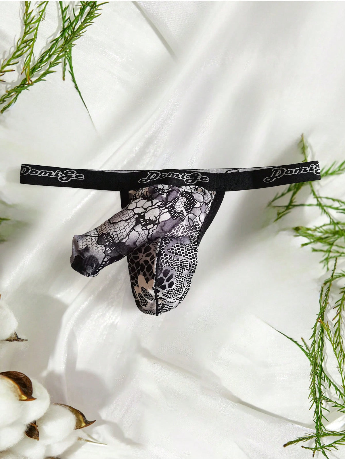 Black and white colorblock low-rise thong underwear for men featuring tape detail and knitted stretch fabric.