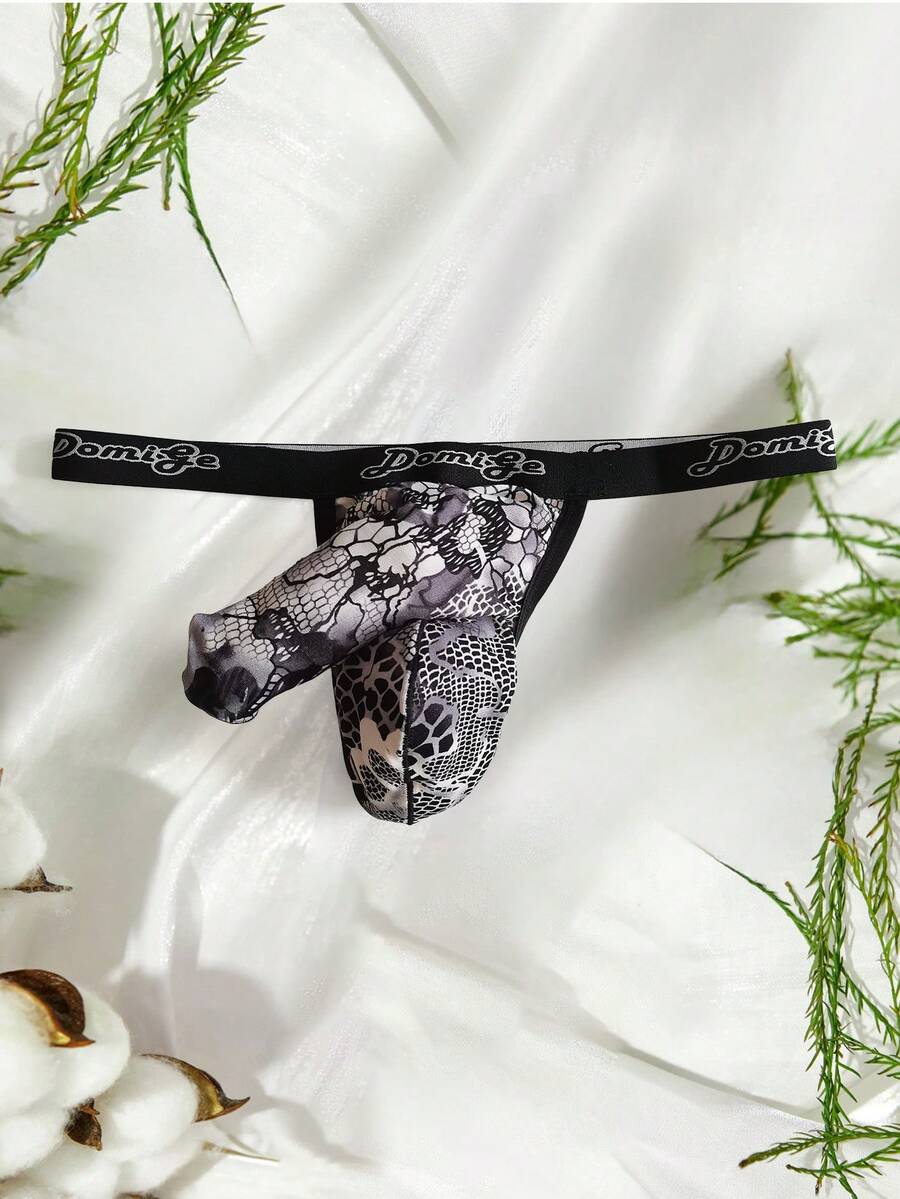 Black and white colorblock low-rise thong underwear for men featuring tape detail and knitted stretch fabric.