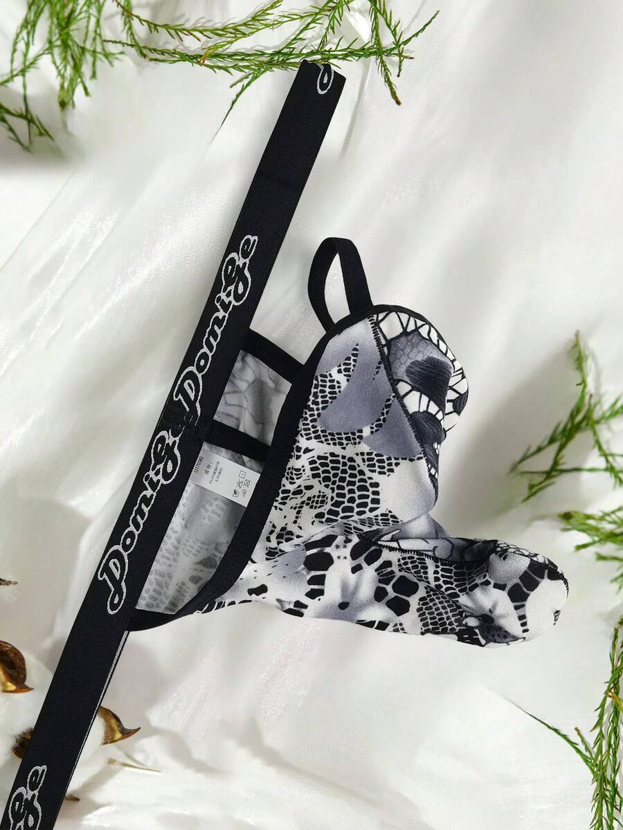 Black and white colorblock low-rise thong underwear for men featuring tape detail and knitted stretch fabric.