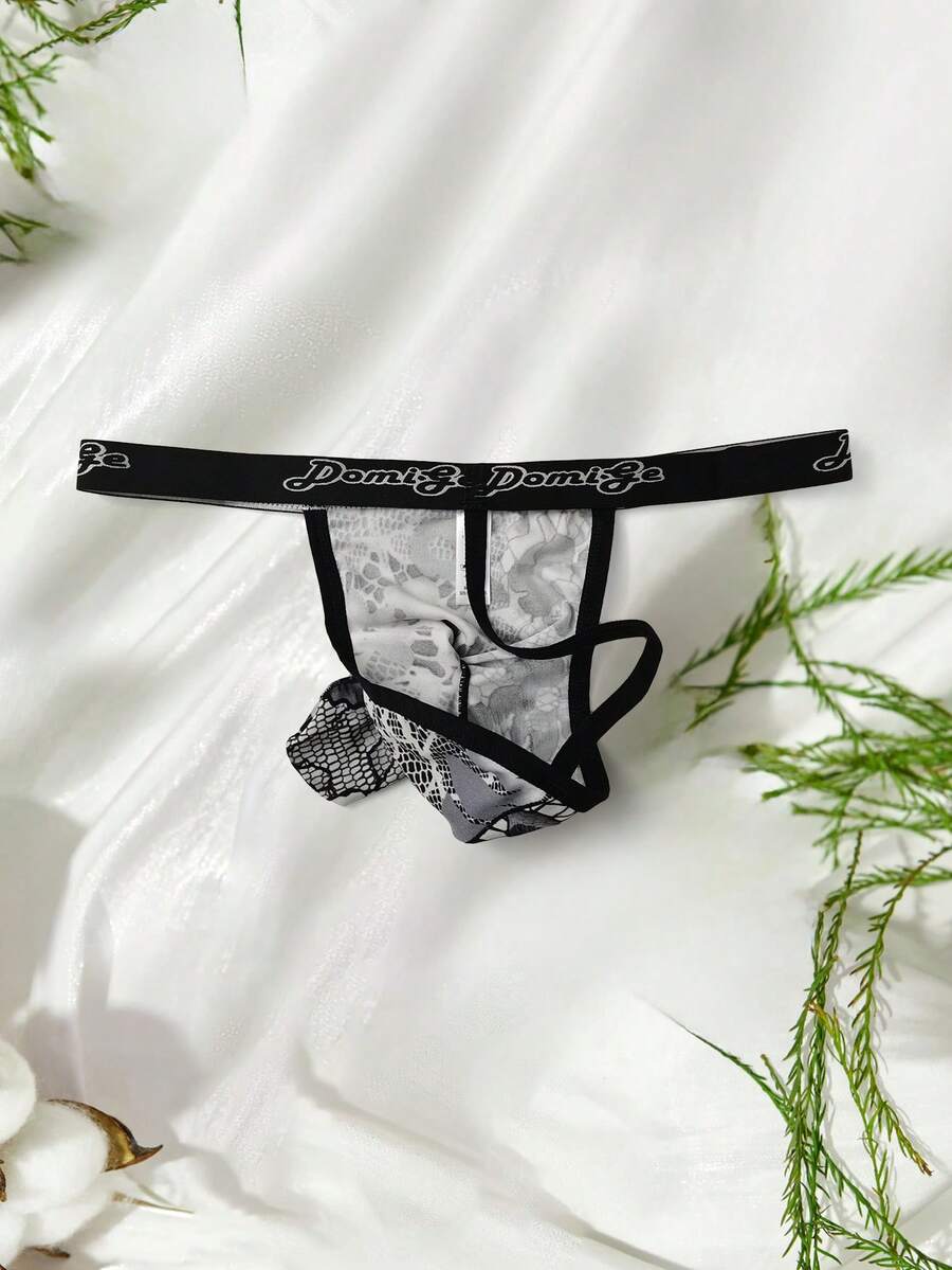 Black and white colorblock low-rise thong underwear for men featuring tape detail and knitted stretch fabric.