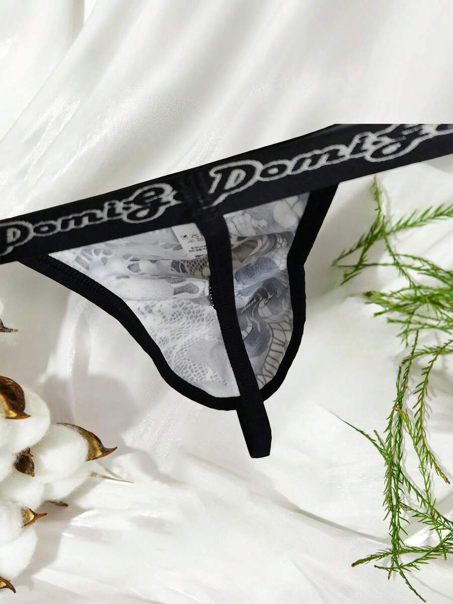 Black and white colorblock low-rise thong underwear for men featuring tape detail and knitted stretch fabric.