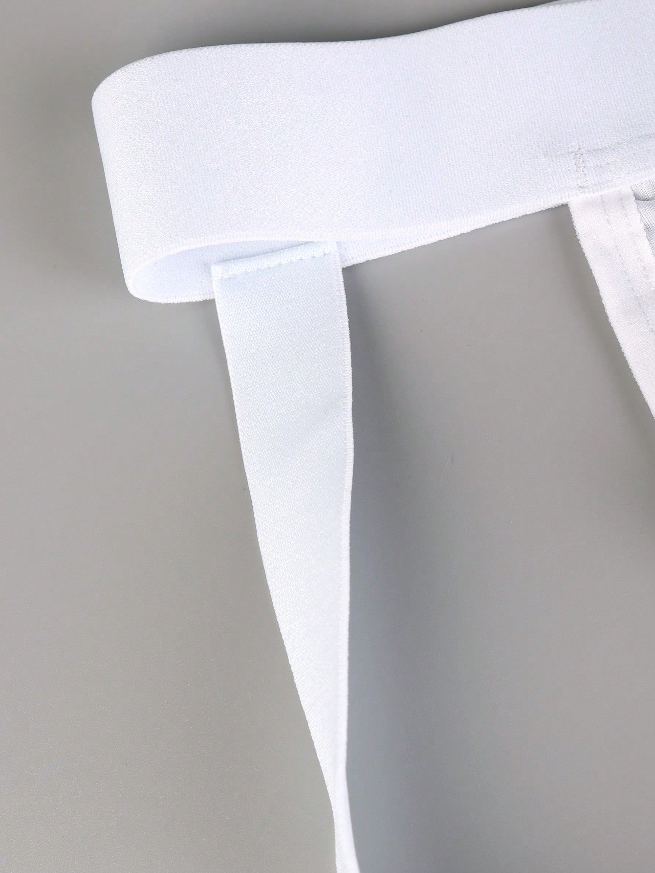 Men's white G-string underwear in knitted fabric with tape detail, mid-rise fit, and medium stretch for daily wear.