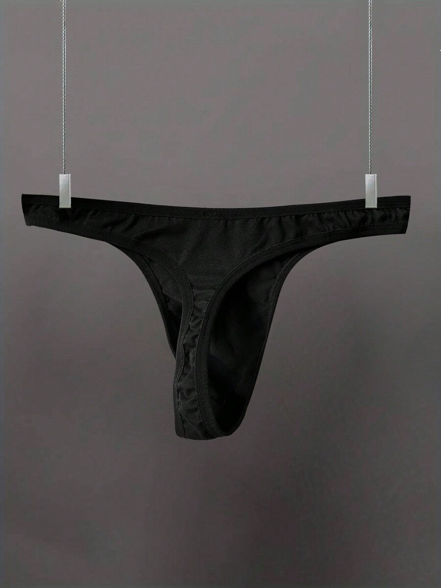 Black low-rise men's thong underwear with letter print pattern made of knitted fabric.
