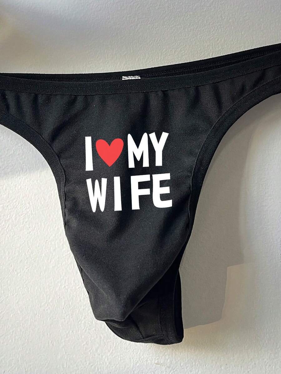 Black low-rise men's thong underwear with letter print pattern made of knitted fabric.