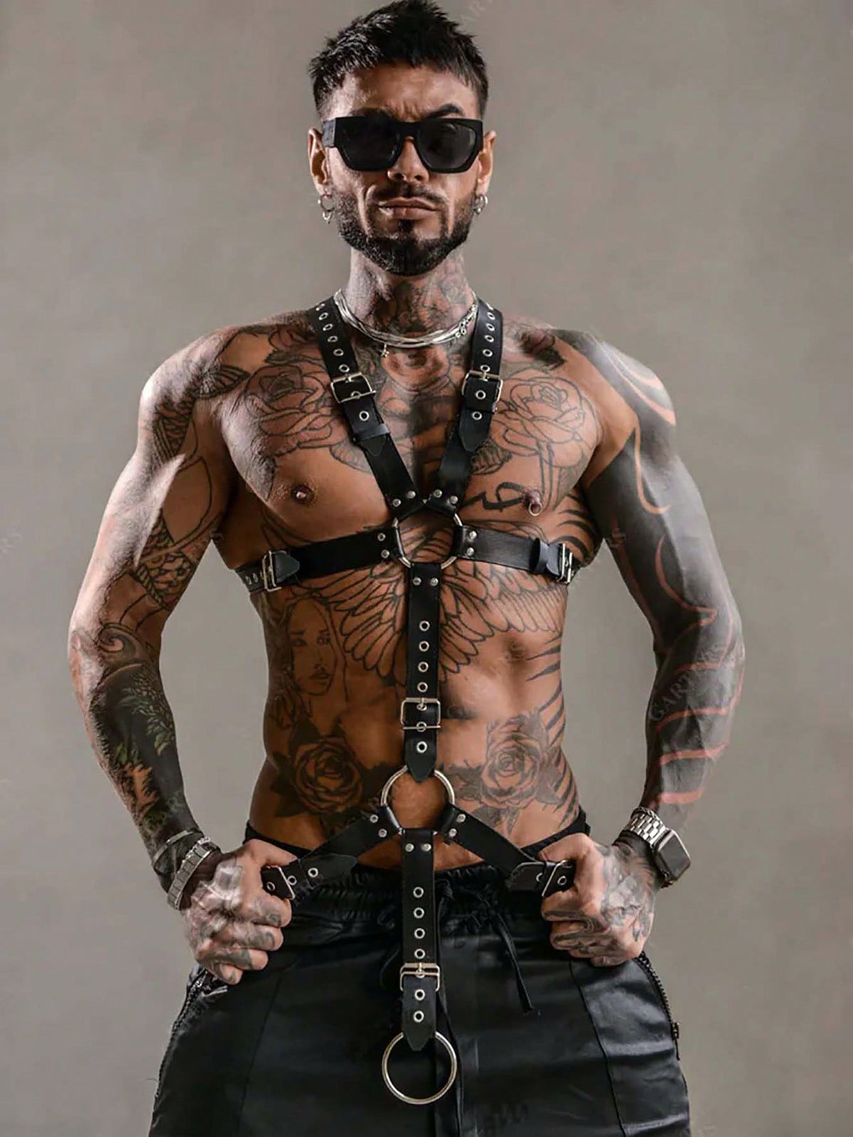 Black PU leather chest harness for men with adjustable straps, rivet details, and a metal O-ring back design.