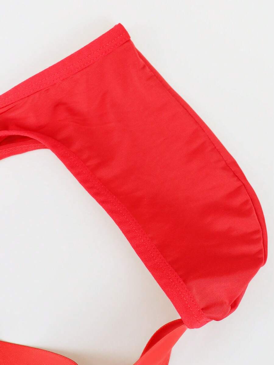 Red men's low-rise jockstrap underwear featuring criss-cross cut-out details in medium stretch knitted fabric.