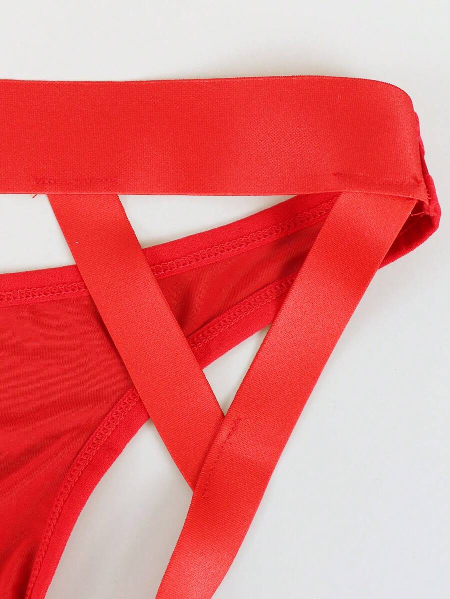 Red men's low-rise jockstrap underwear featuring criss-cross cut-out details in medium stretch knitted fabric.