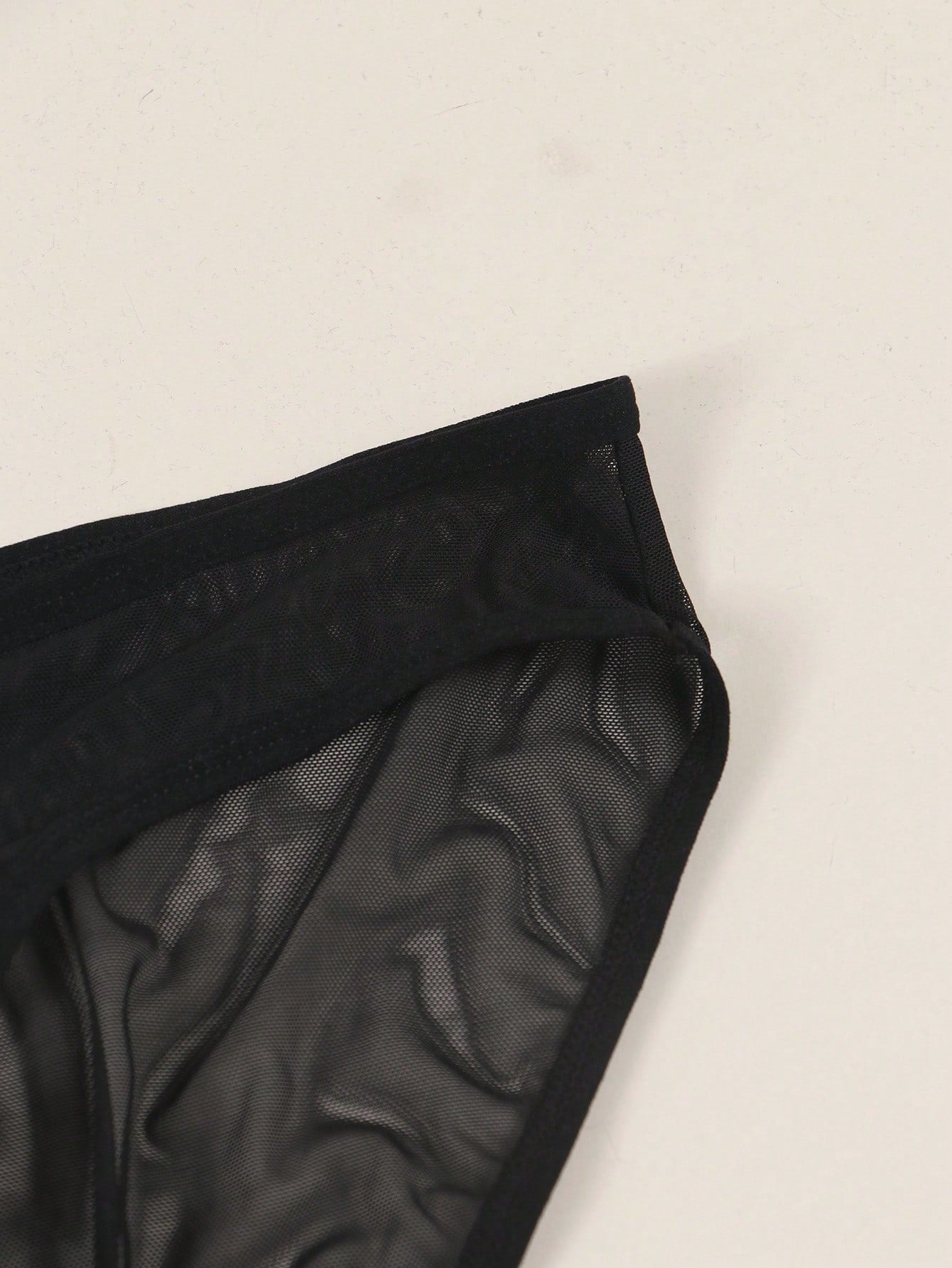 Men's solid color triangle mesh briefs with a large pouch, mid-rise waist, and breathable stretch polyamide fabric for daily wear.