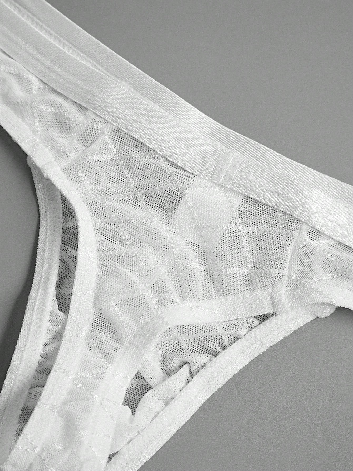 Men's sheer mesh thong underwear in multicolor with low-rise cut, plaid and random print pattern, and high-stretch polyamide elastane fabric.