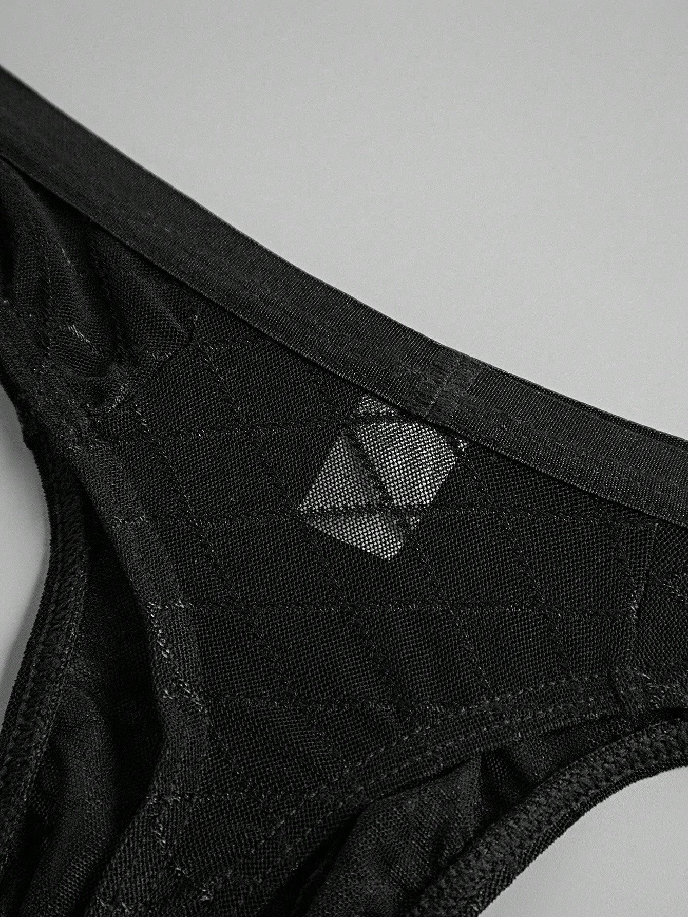 Men's sheer mesh thong underwear in multicolor with low-rise cut, plaid and random print pattern, and high-stretch polyamide elastane fabric.