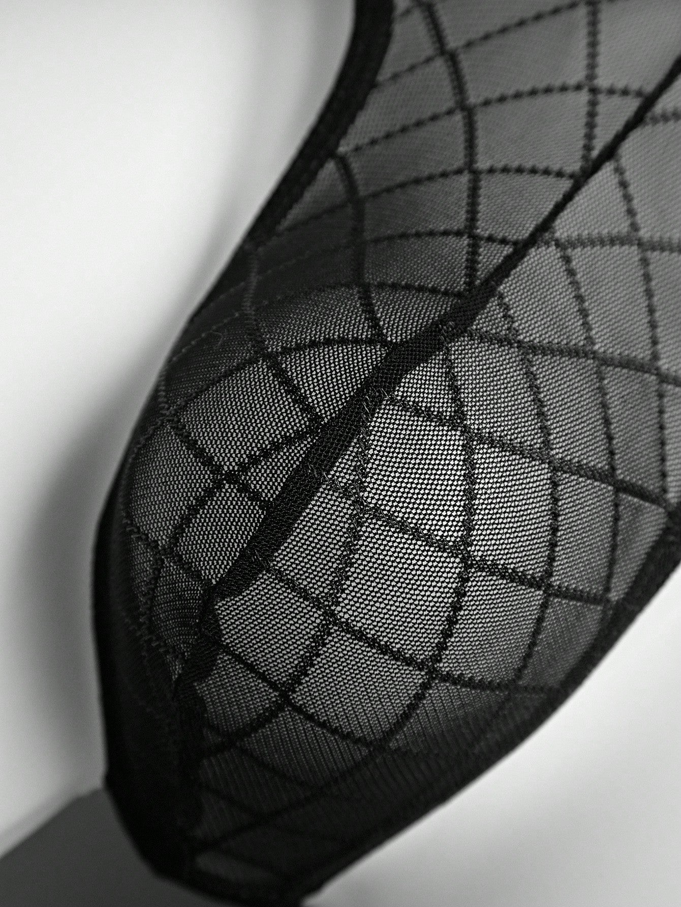 Men's sheer mesh thong underwear in multicolor with low-rise cut, plaid and random print pattern, and high-stretch polyamide elastane fabric.