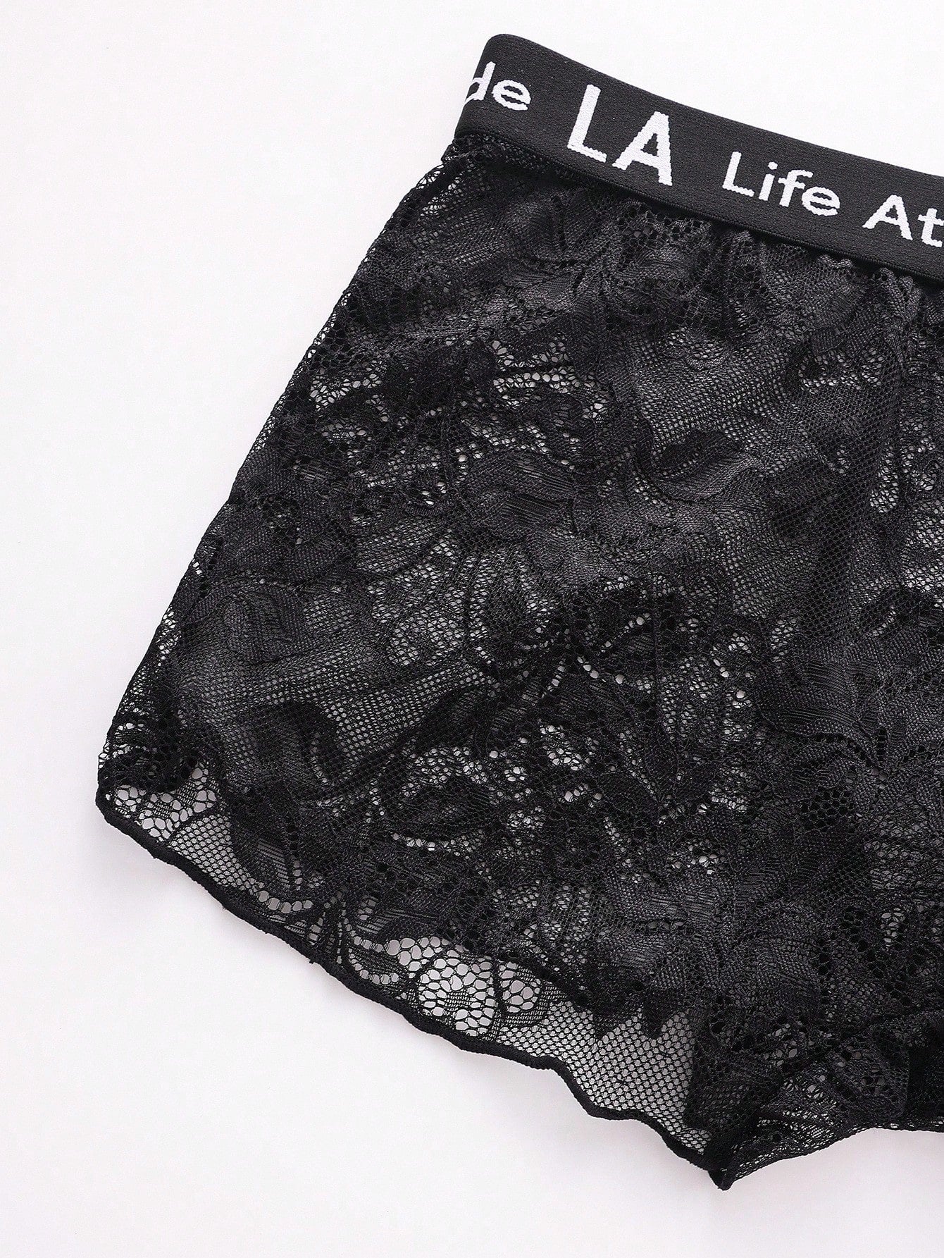 Men's black low rise lace briefs with letter waistband, semi-sheer fabric and medium stretch design.