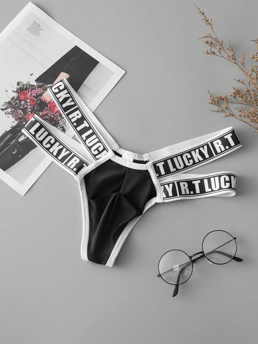 Black low-rise men's thong underwear featuring a belted waist detail and letter pattern on knitted fabric.