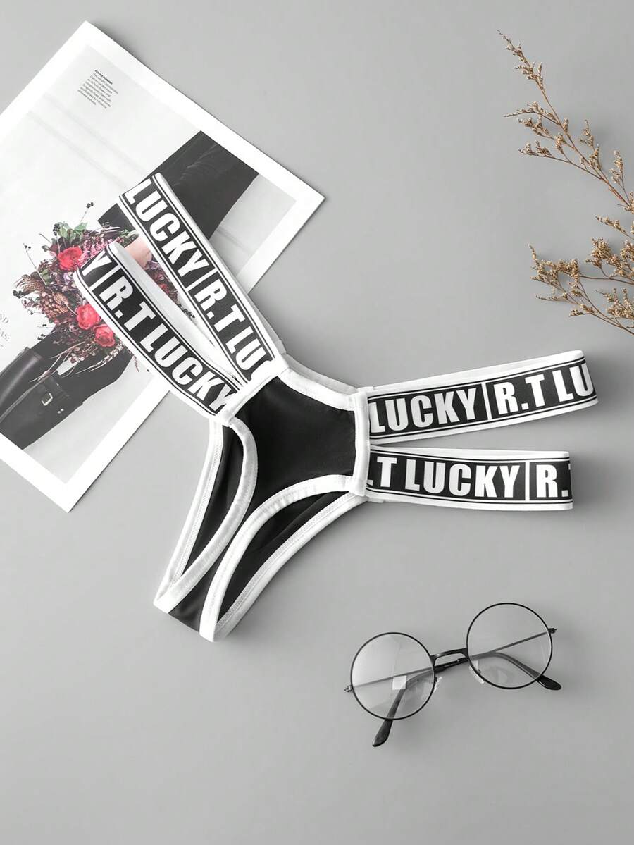 Black low-rise men's thong underwear featuring a belted waist detail and letter pattern on knitted fabric.