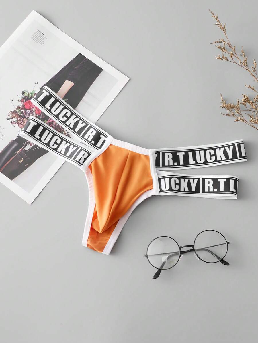 Black low-rise men's thong underwear featuring a belted waist detail and letter pattern on knitted fabric.