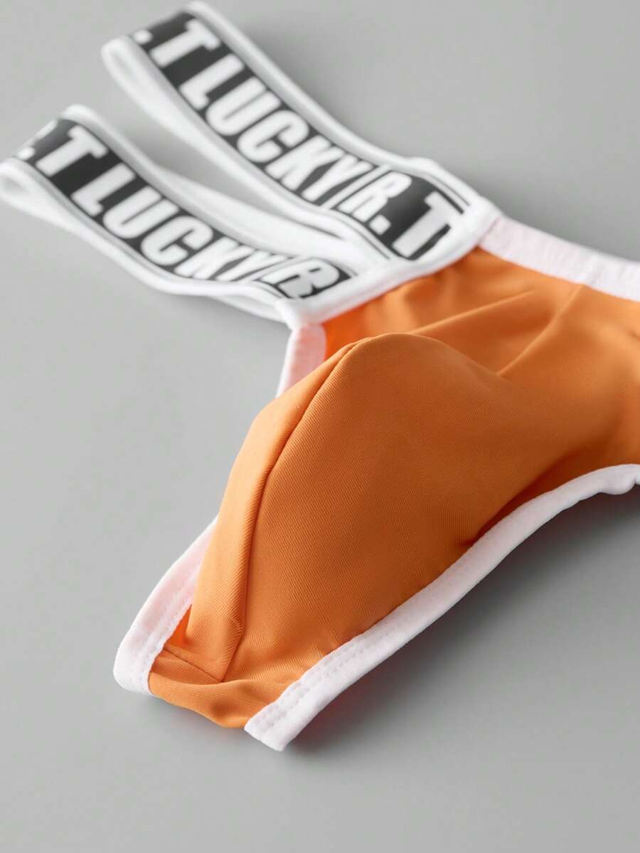 Black low-rise men's thong underwear featuring a belted waist detail and letter pattern on knitted fabric.