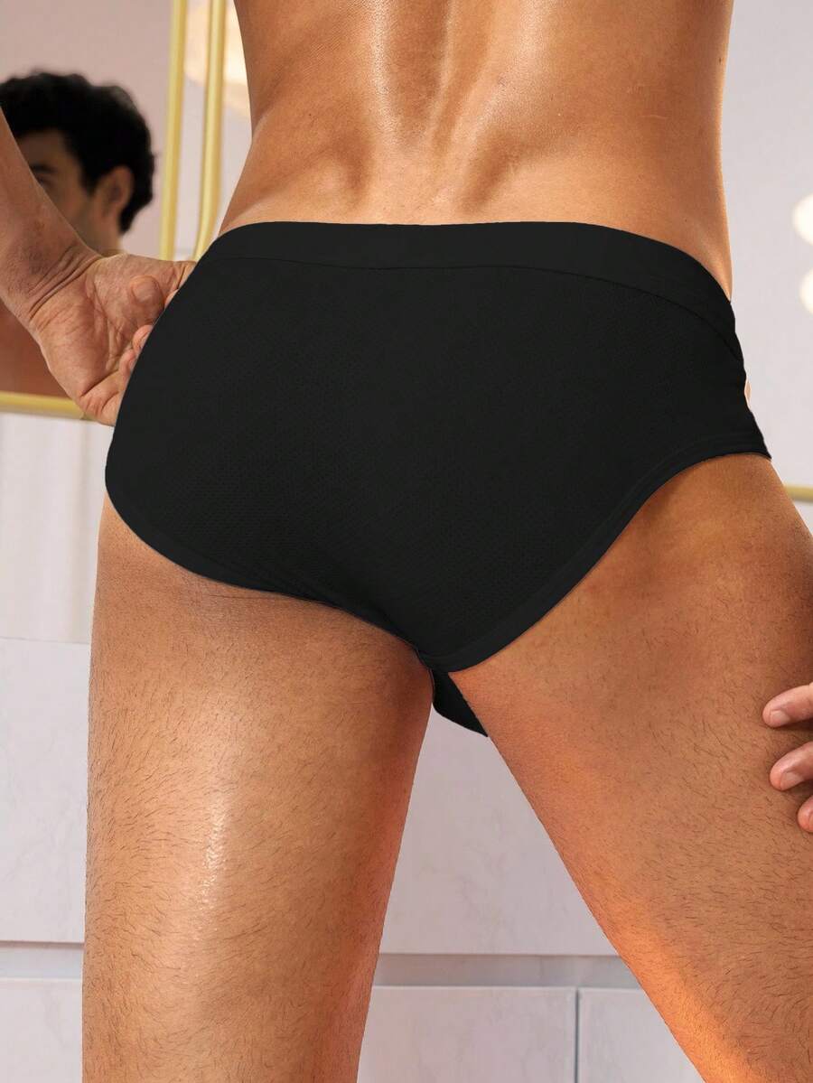 Black low rise knitted men's briefs featuring a plain pattern and elastic fabric.