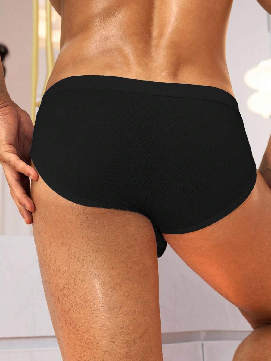 Black low rise knitted men's briefs featuring a plain pattern and elastic fabric.