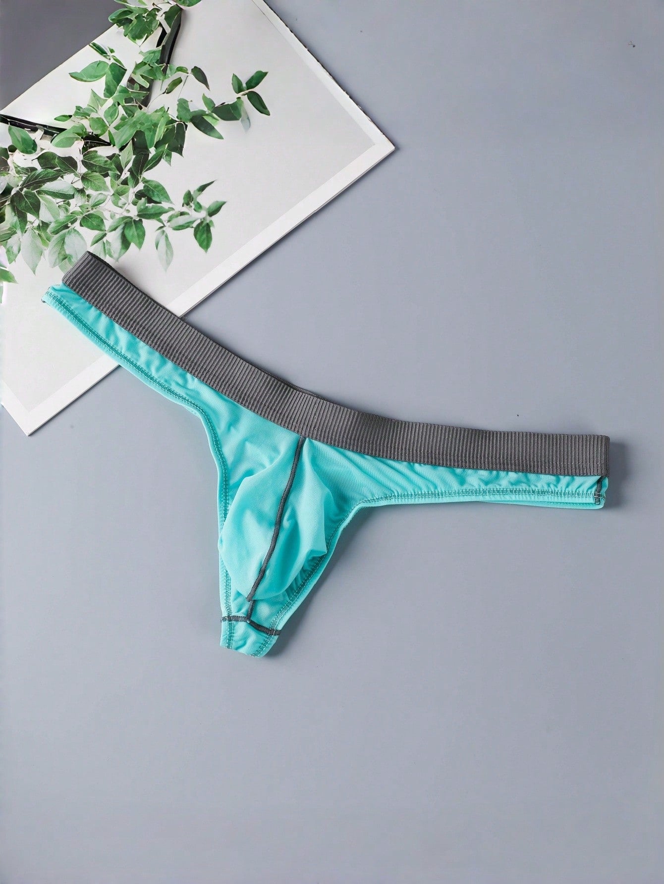 Blue men's thong underwear with contrast binding and a low-rise design in medium-stretch polyamide elastane fabric.