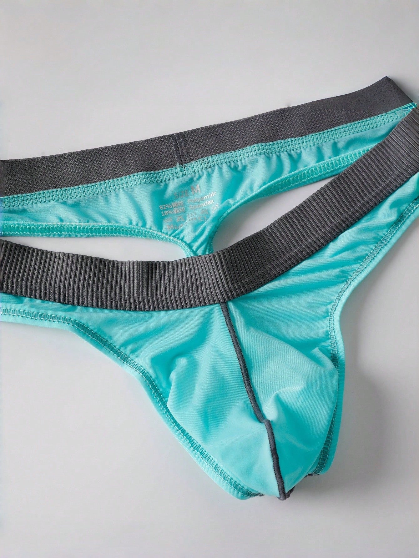 Blue men's thong underwear with contrast binding and a low-rise design in medium-stretch polyamide elastane fabric.