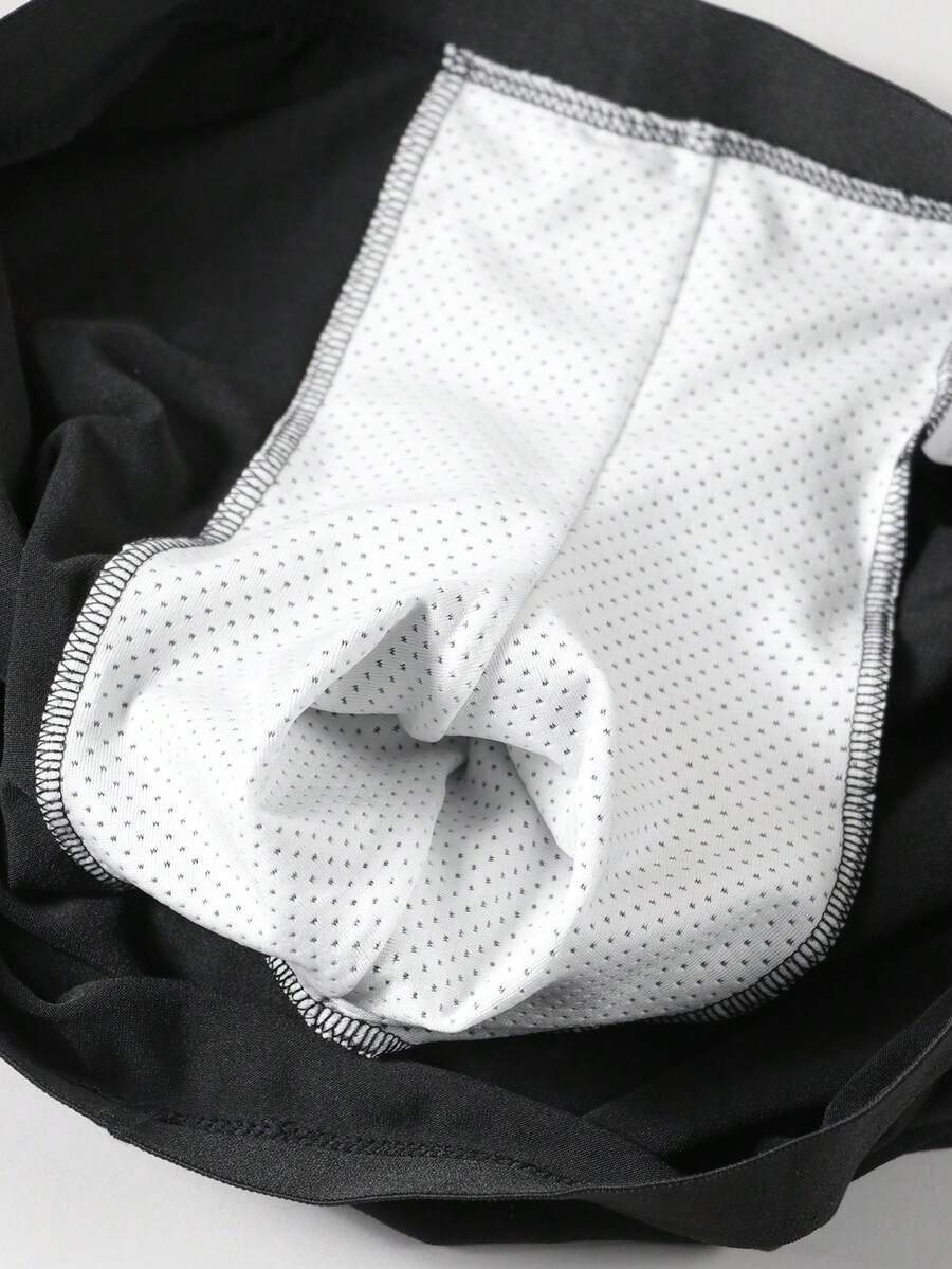 Black men's elephant pouch boxer shorts featuring letter print design and high-stretch fabric.
