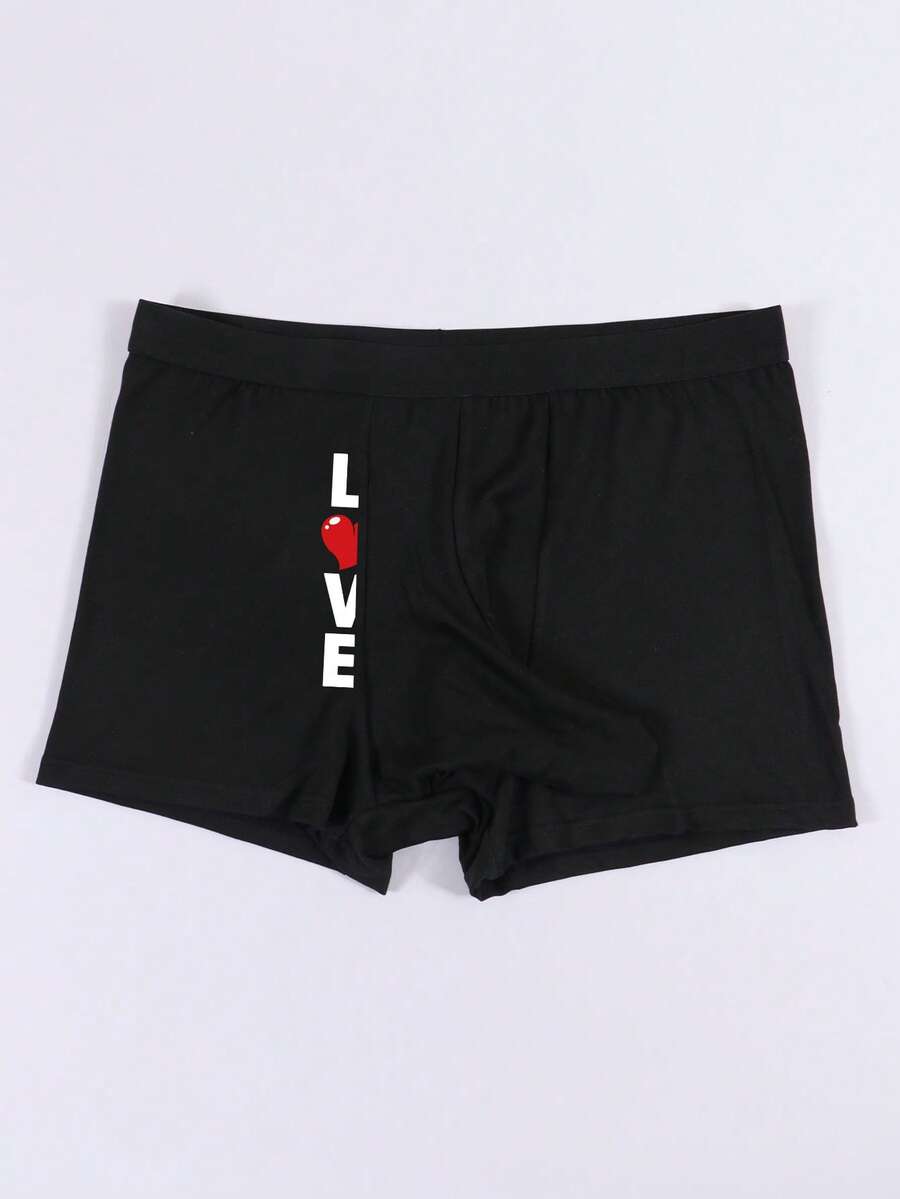 Black men's elephant pouch boxer shorts featuring letter print design and high-stretch fabric.