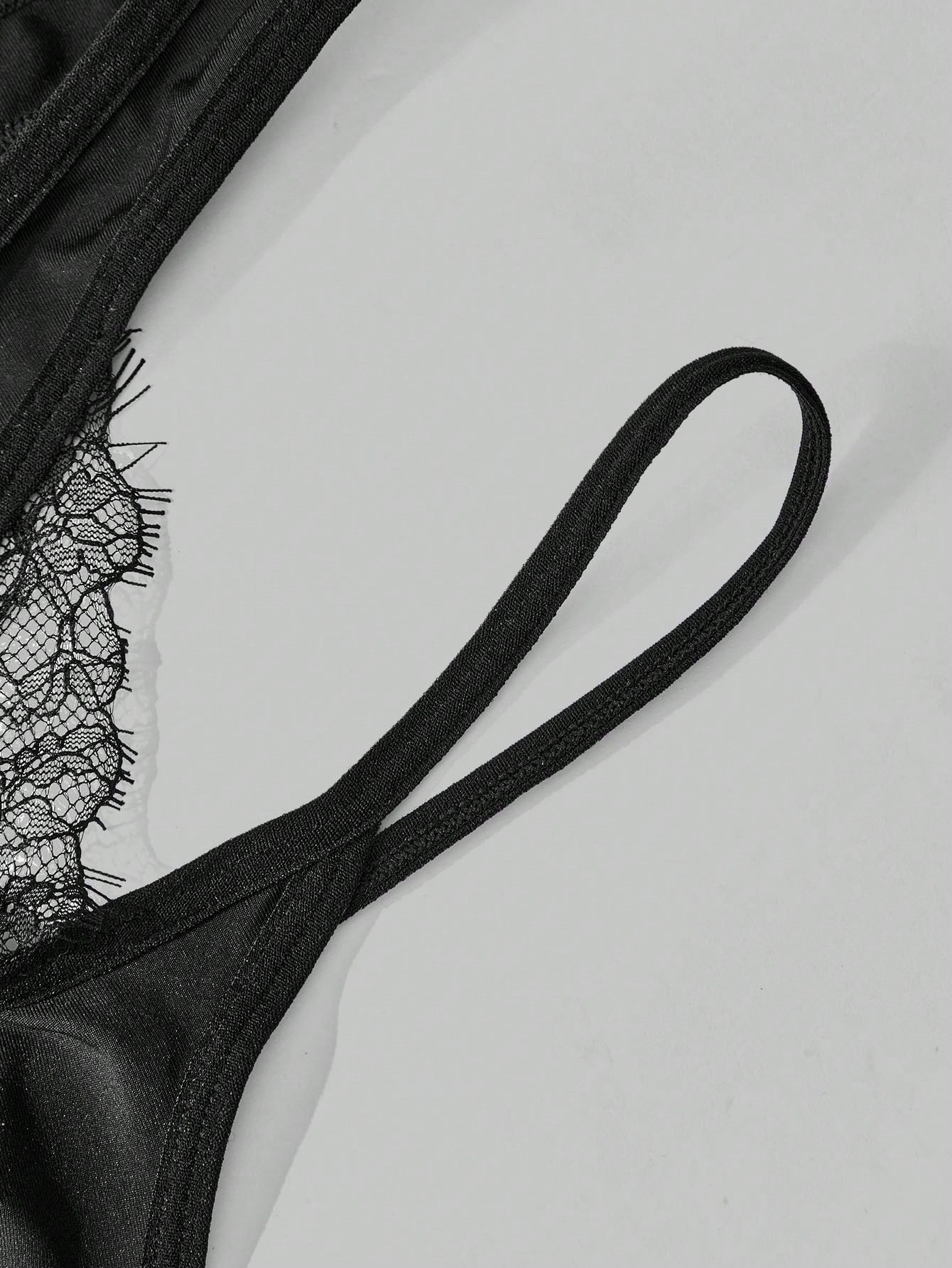 Men's black lace thong lingerie with a low-rise fit, medium-stretch fabric, and unlined design for party or Halloween wear.