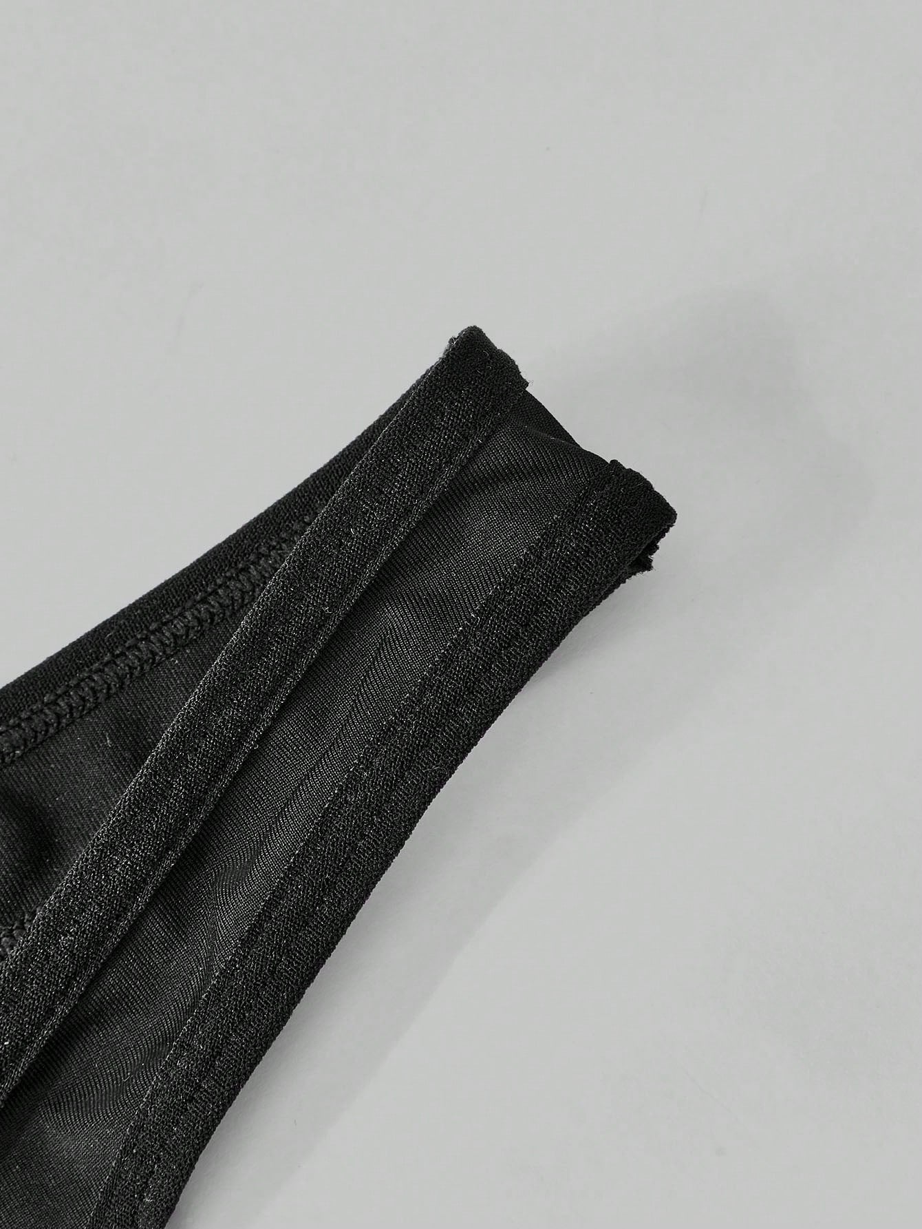 Men's black lace thong lingerie with a low-rise fit, medium-stretch fabric, and unlined design for party or Halloween wear.