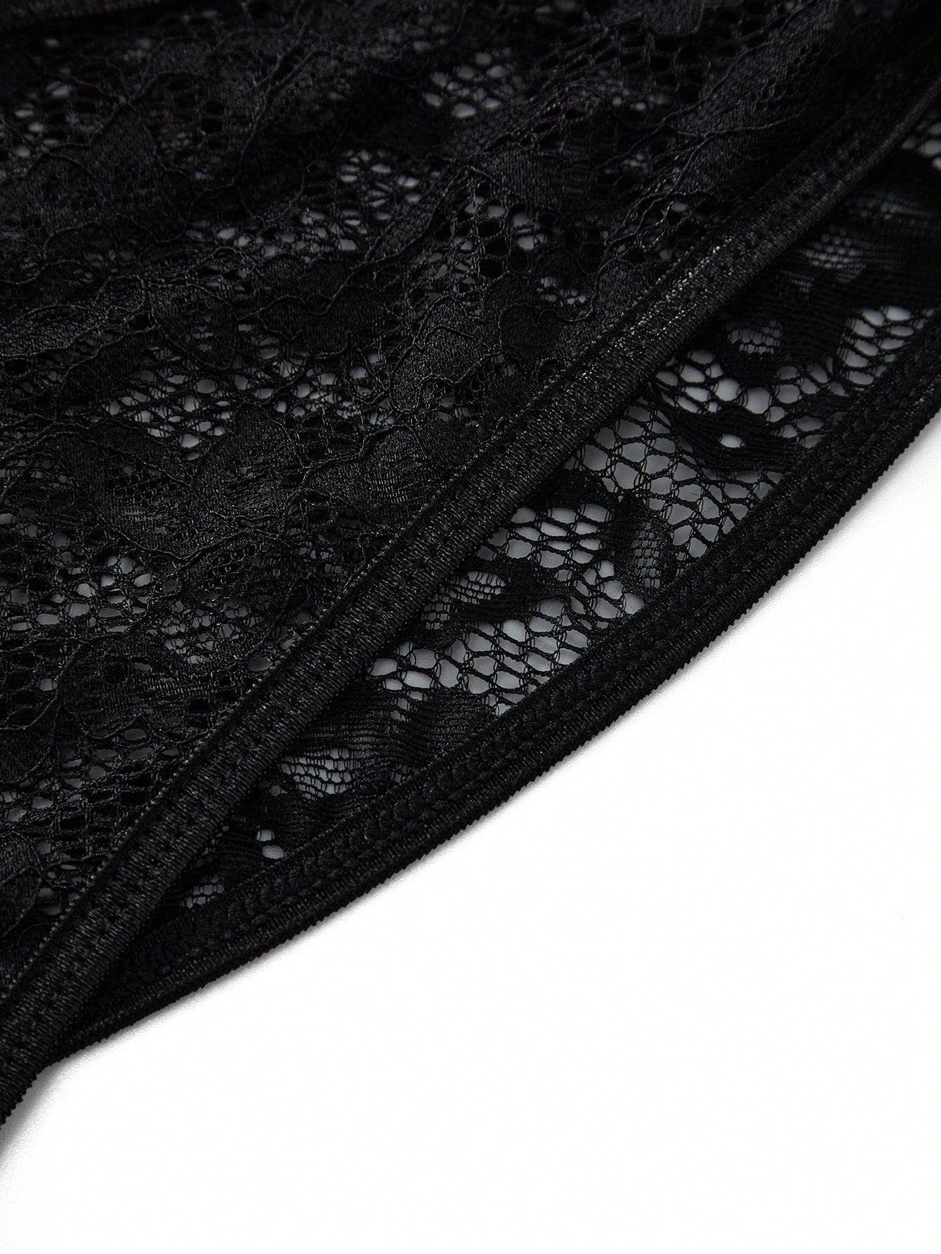 Men's black lace jockstrap thong underwear with hollow out detail, low rise waist, semi-sheer fabric, and medium stretch polyamide elastane blend.