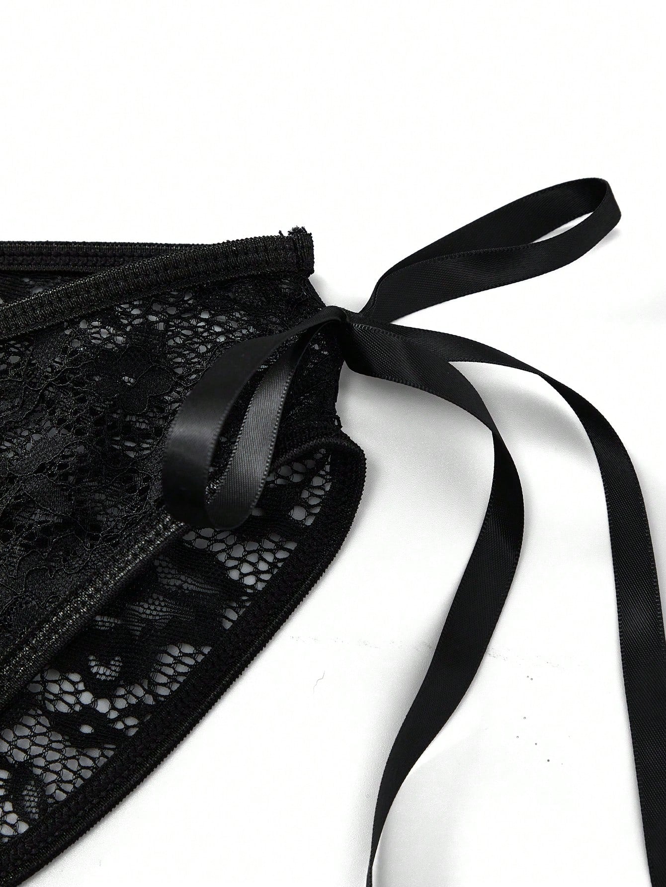 Men's black lace jockstrap thong underwear with hollow out detail, low rise waist, semi-sheer fabric, and medium stretch polyamide elastane blend.