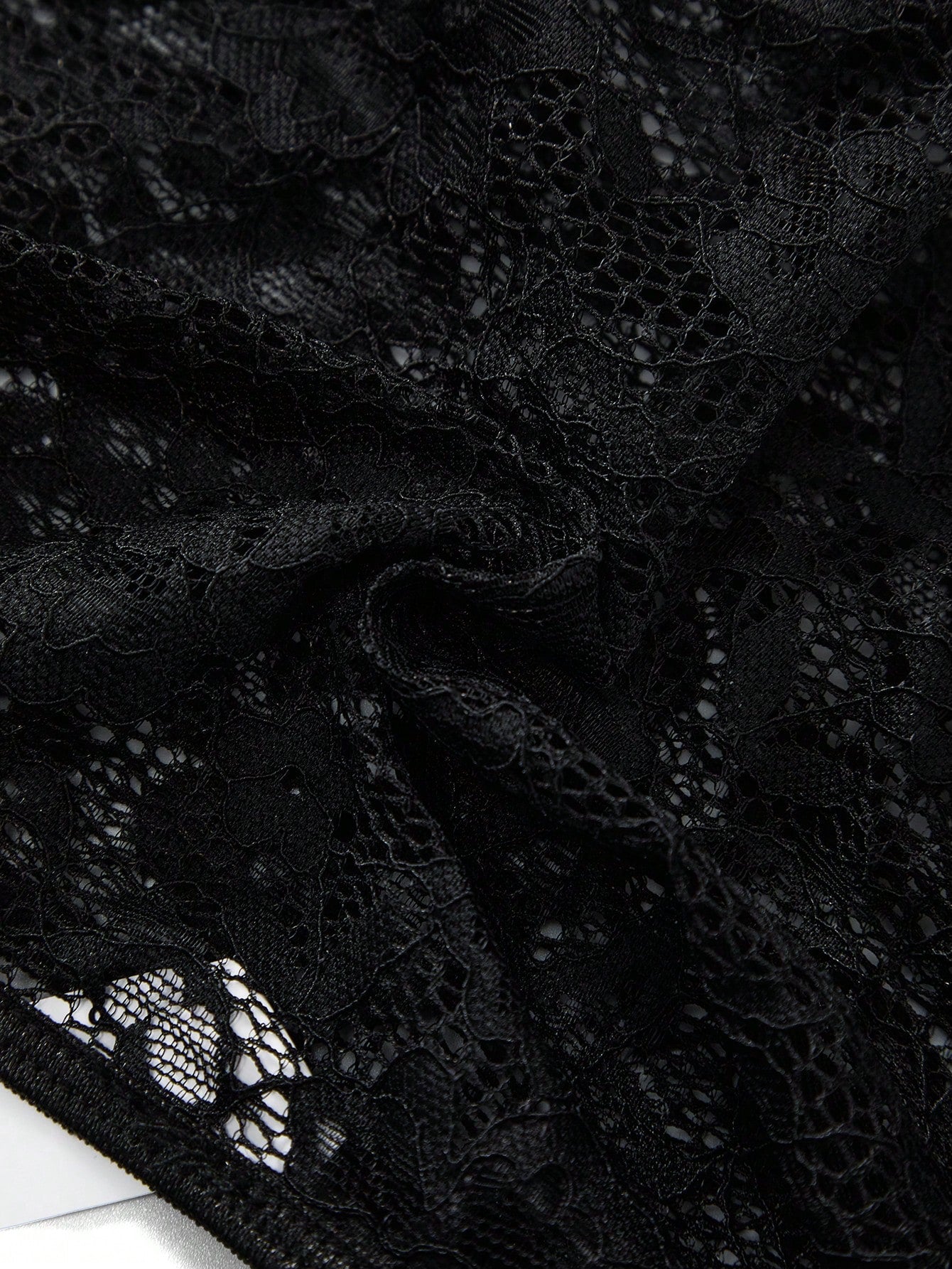 Men's black lace jockstrap thong underwear with hollow out detail, low rise waist, semi-sheer fabric, and medium stretch polyamide elastane blend.