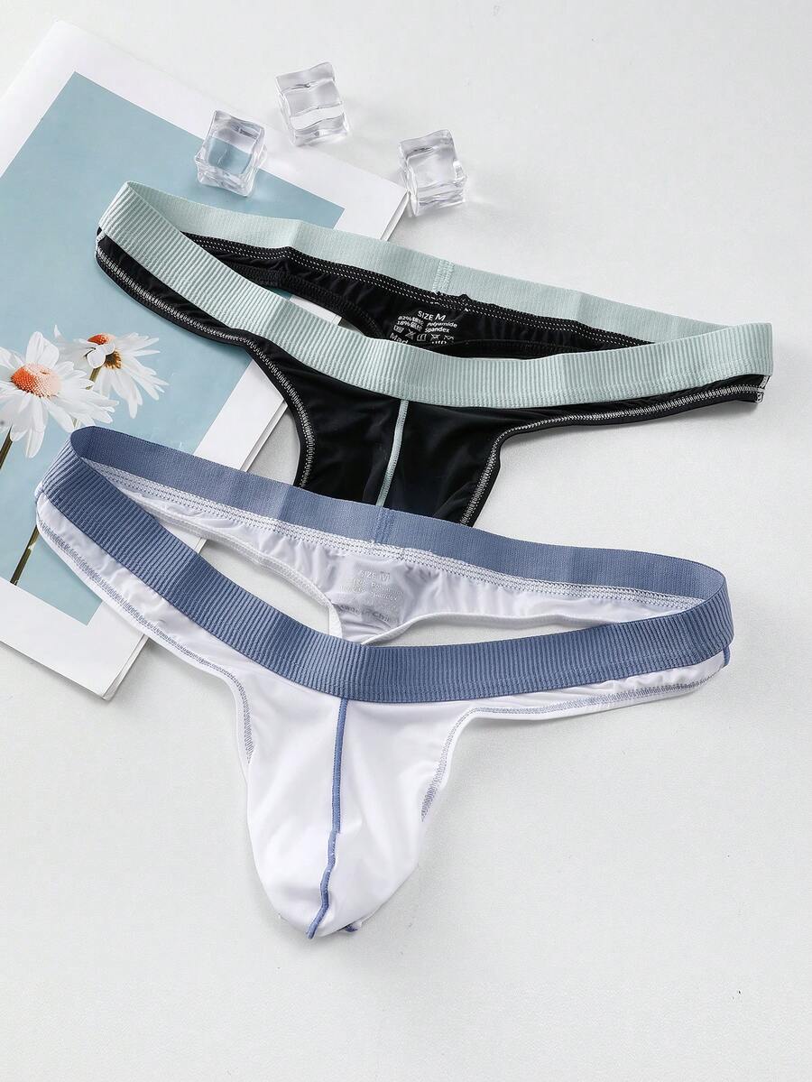 Set of two men's low-rise thong underwear featuring multicolor plant print and contrast waistband.
