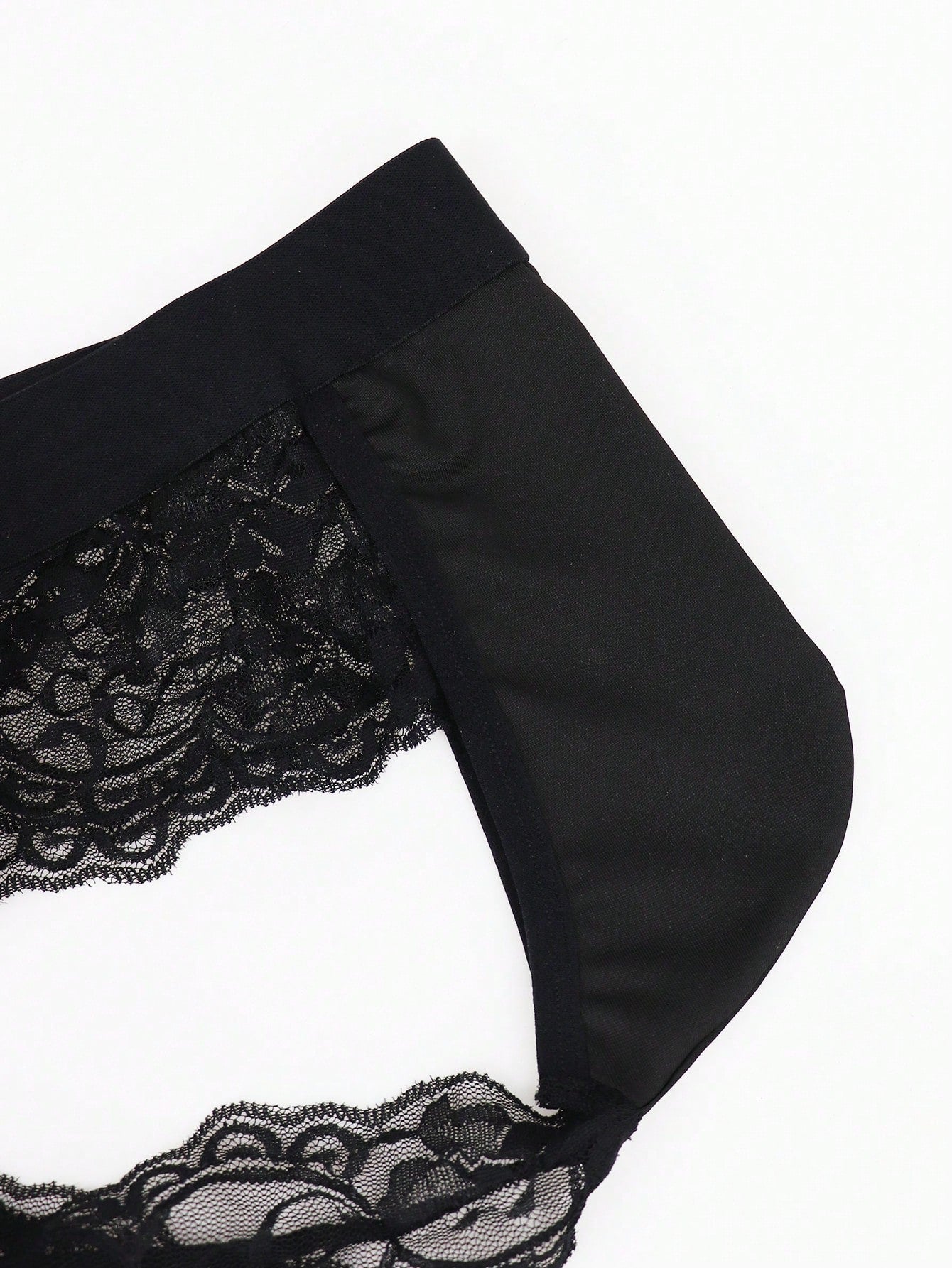 Men's black mid-rise thong briefs in knitted polyamide elastane fabric with medium stretch and plant pattern.