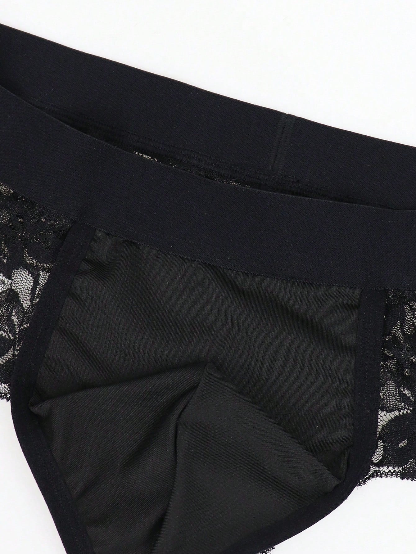Men's black mid-rise thong briefs in knitted polyamide elastane fabric with medium stretch and plant pattern.