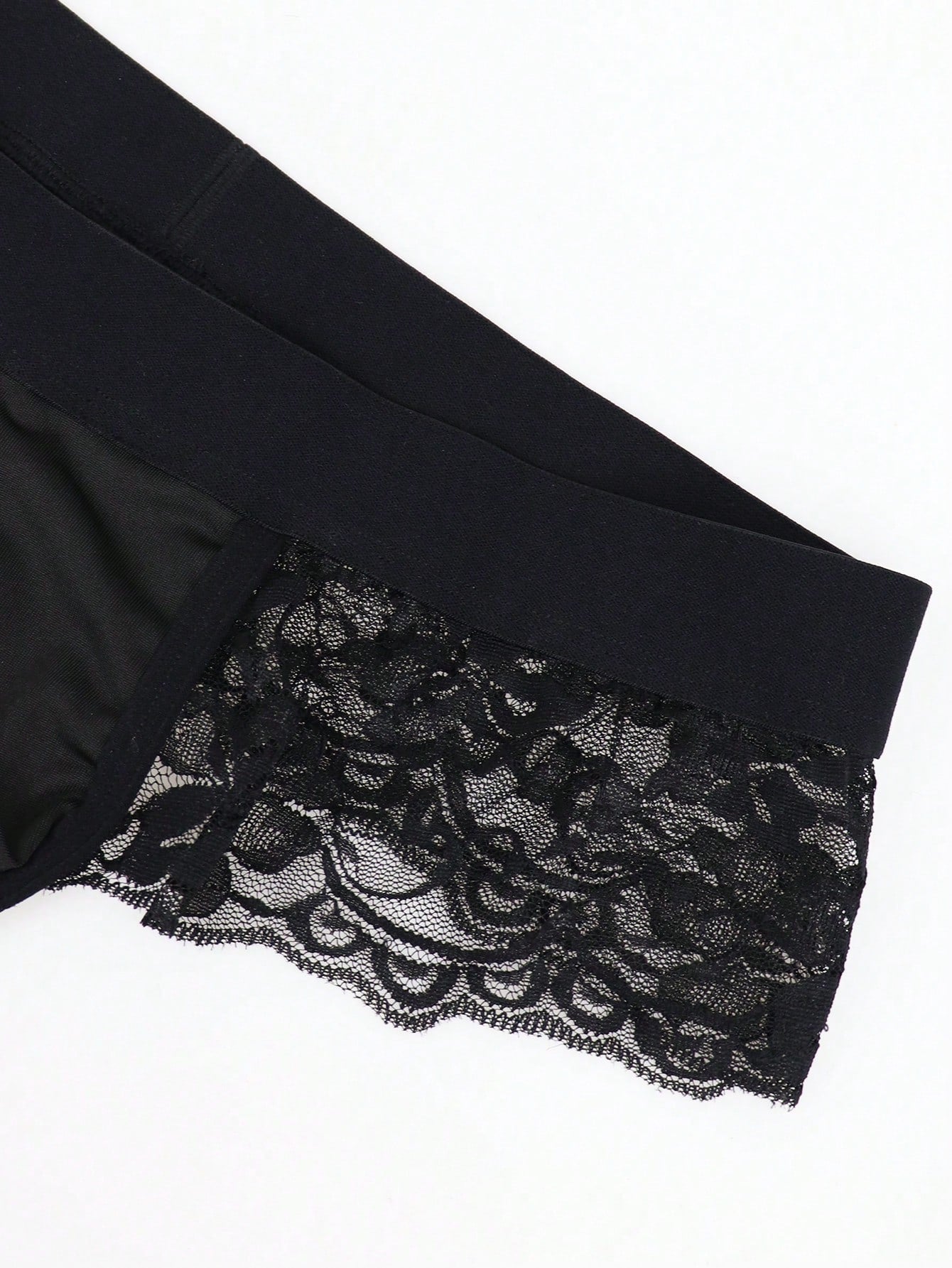 Men's black mid-rise thong briefs in knitted polyamide elastane fabric with medium stretch and plant pattern.