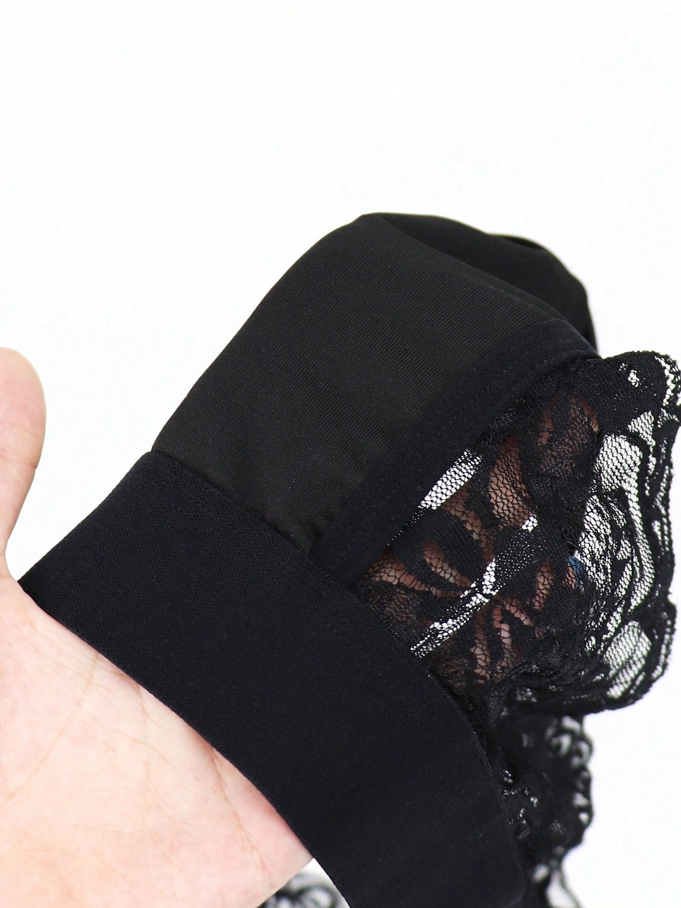 Men's black mid-rise thong briefs in knitted polyamide elastane fabric with medium stretch and plant pattern.
