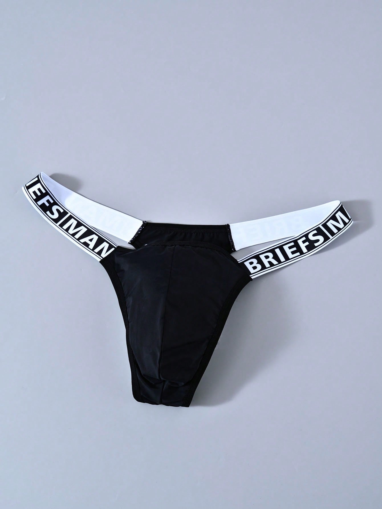 Men's mid rise thong underwear with textured pattern and letter-style tape waistband, made from polyester elastane stretch fabric.