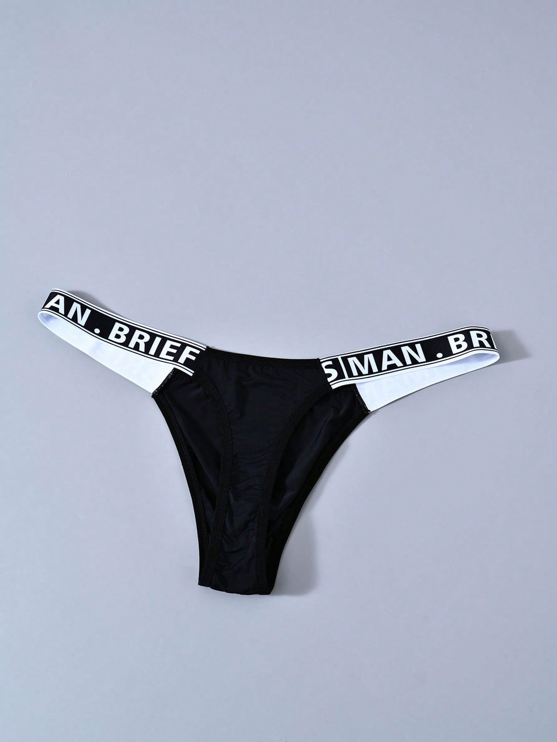 Men's mid rise thong underwear with textured pattern and letter-style tape waistband, made from polyester elastane stretch fabric.