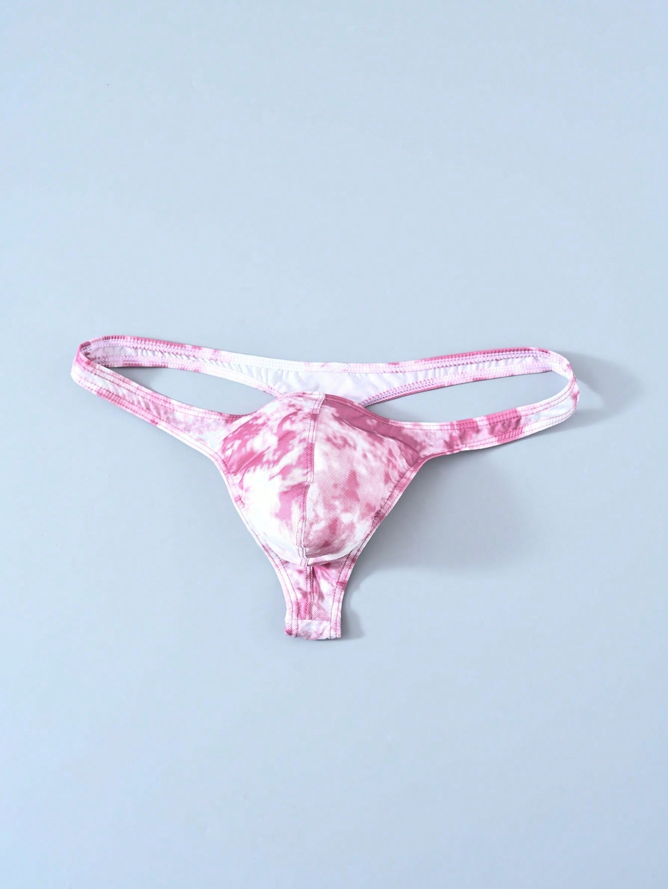 Men's tie dye thong underwear with a low rise fit and T-back design, made from polyester and elastane stretch fabric.