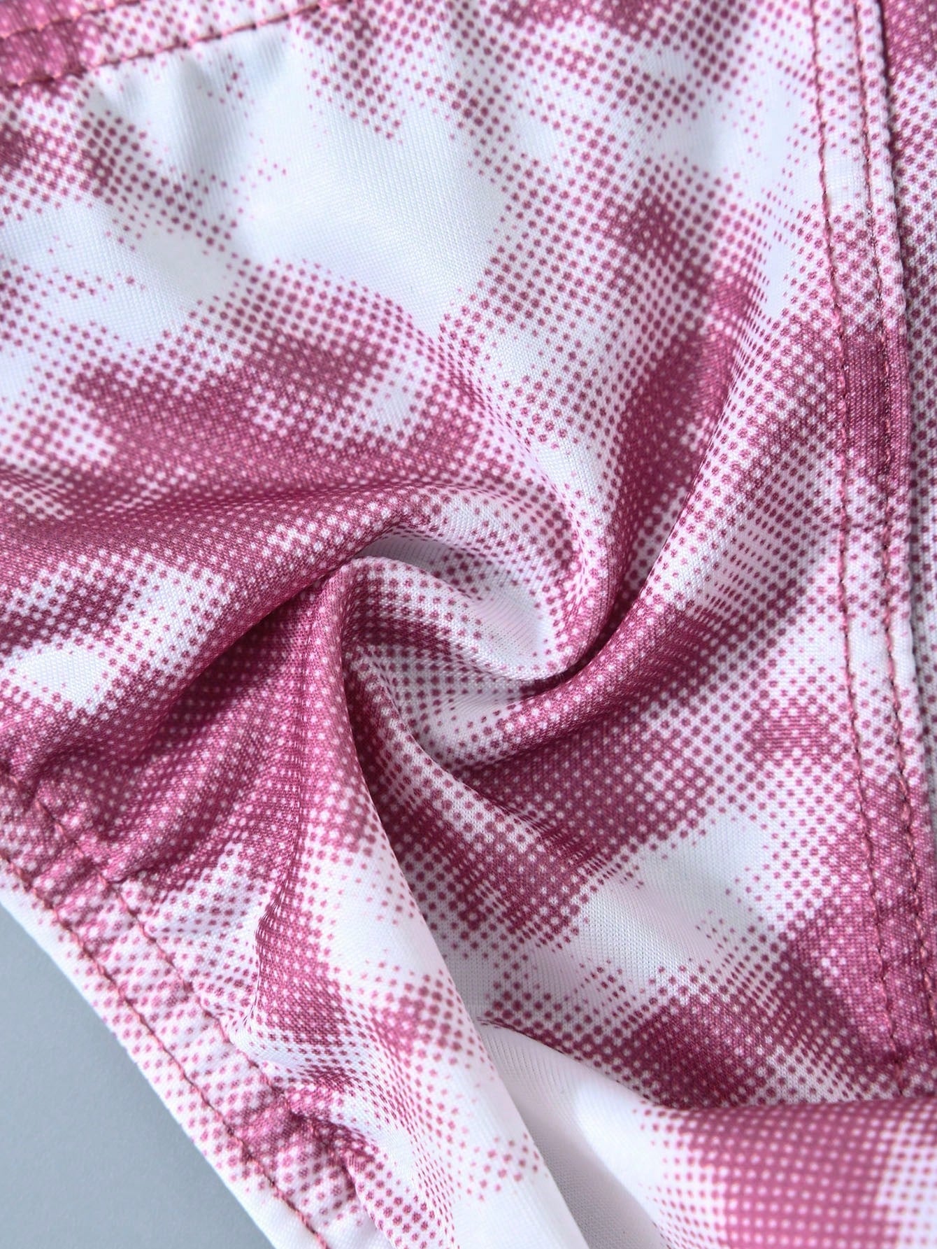 Men's tie dye thong underwear with a low rise fit and T-back design, made from polyester and elastane stretch fabric.