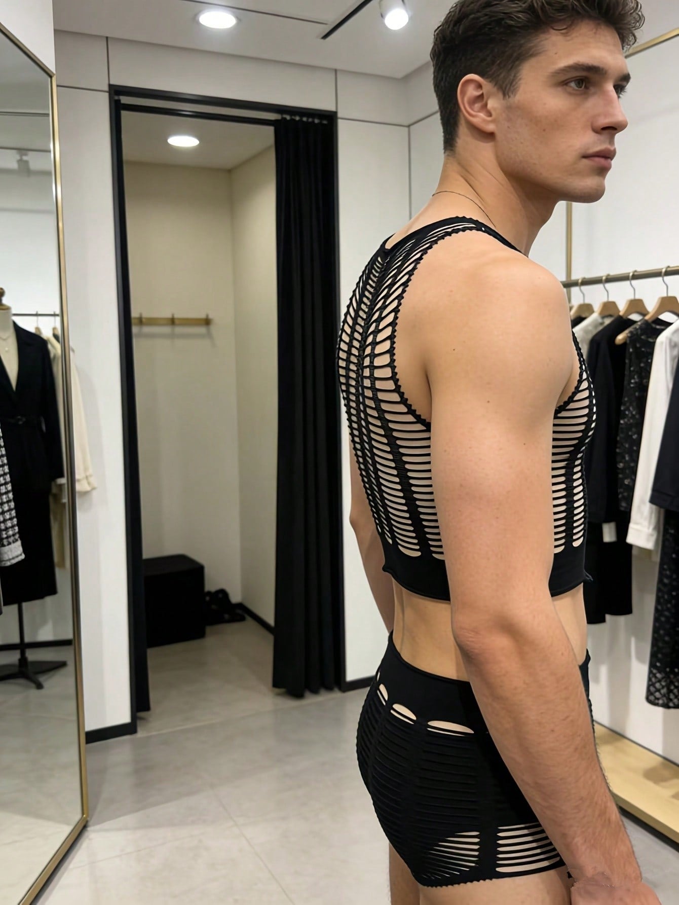 Men's black fishnet lingerie set in sheer knitted fabric with striped pattern, hollow out detail, round neck short top, and matching mid rise bottoms in a 2 piece design.