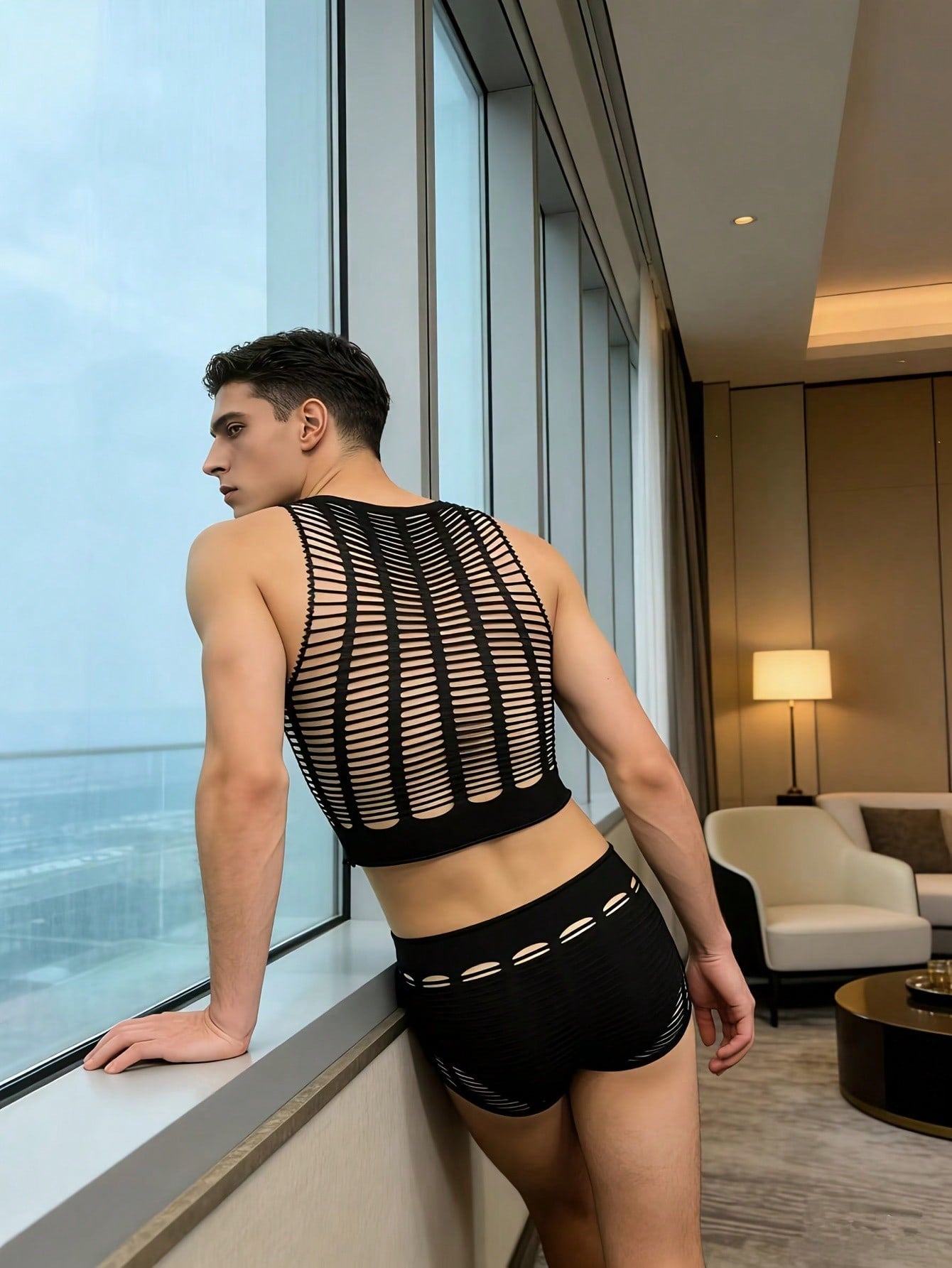 Men's black fishnet lingerie set in sheer knitted fabric with striped pattern, hollow out detail, round neck short top, and matching mid rise bottoms in a 2 piece design.