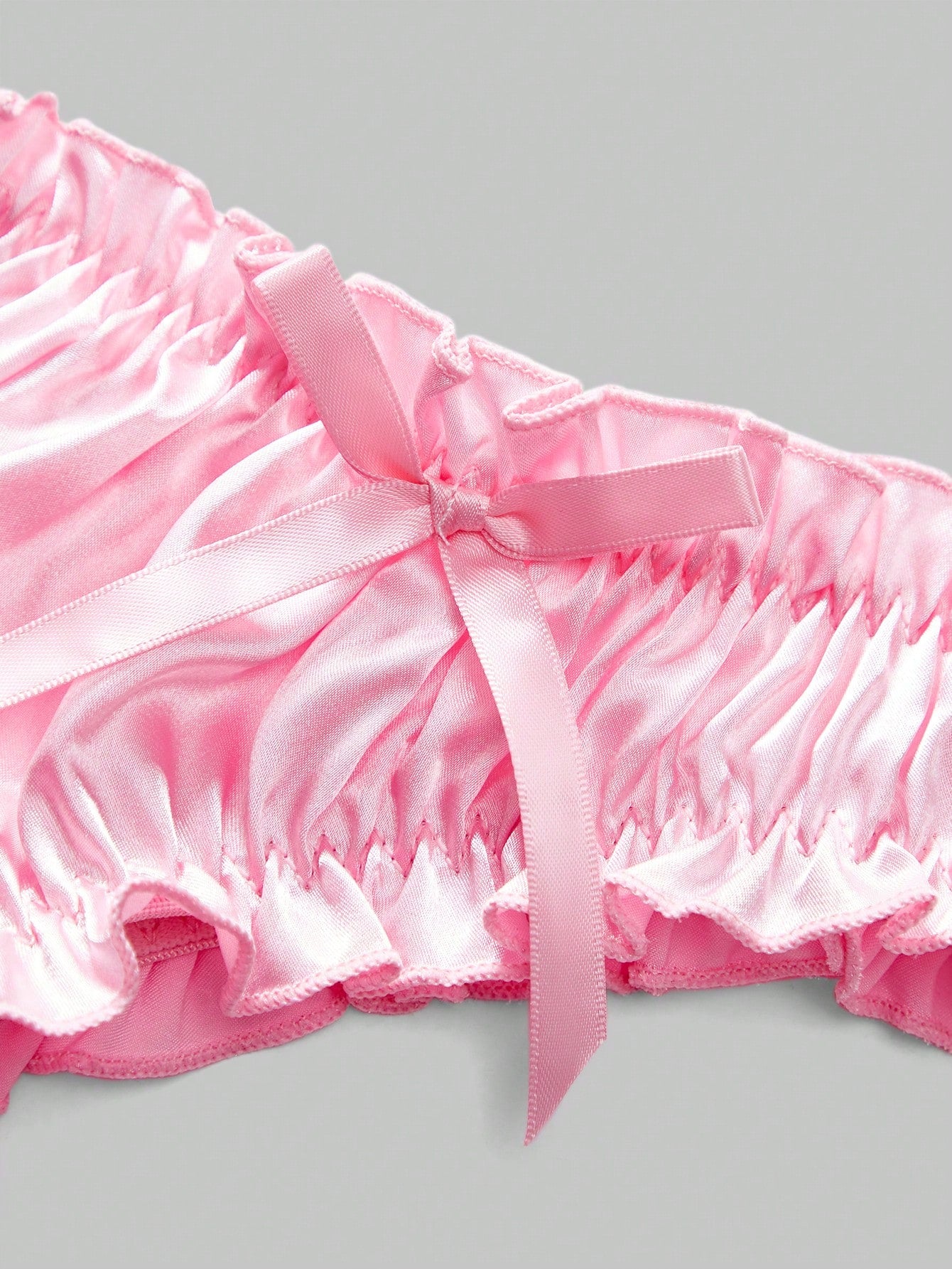 Men's red satin jockstrap briefs with bow decor, pleated design, contrast binding, and a low-rise fit.