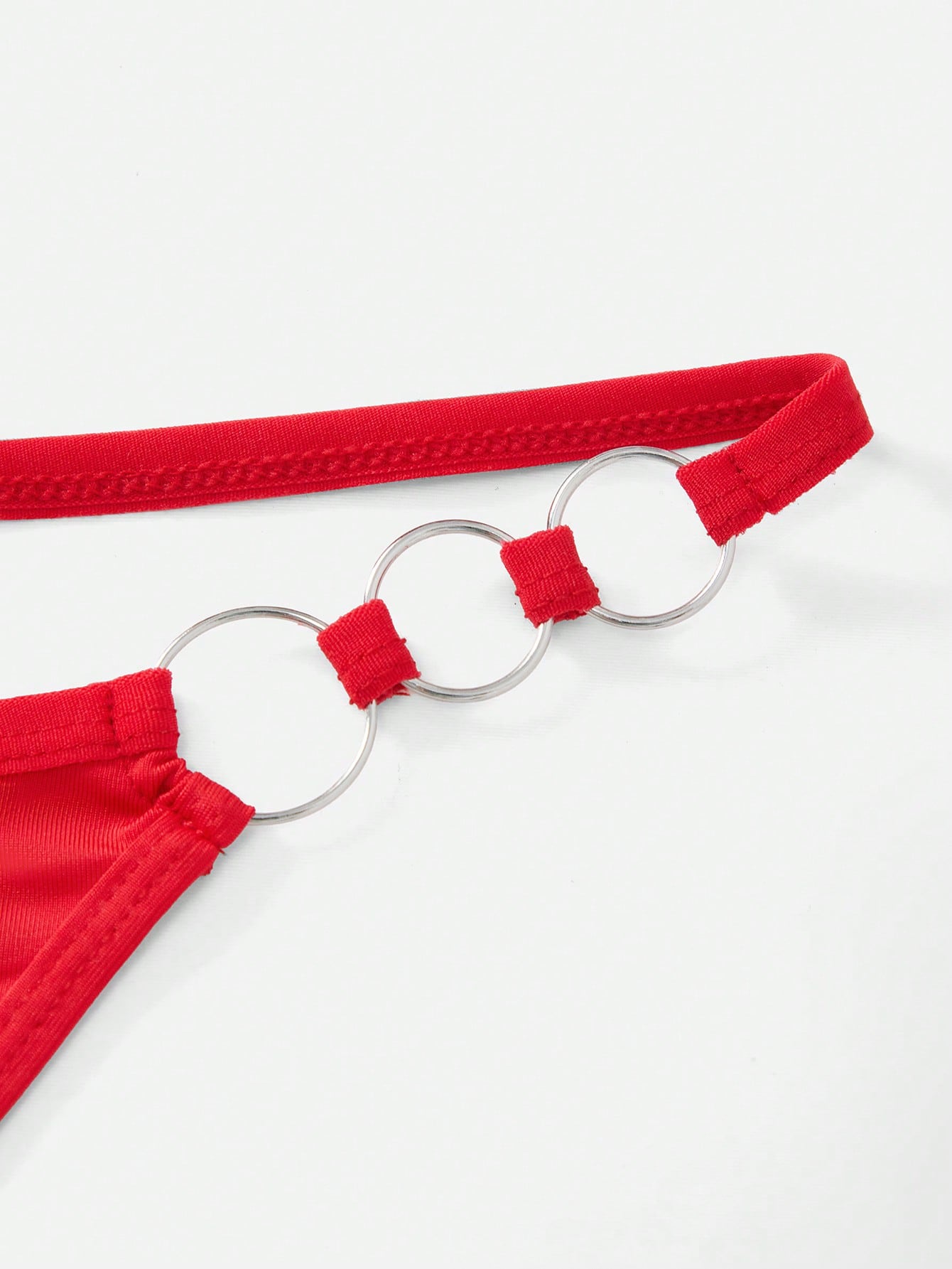 Men's red low rise thong underwear with metal decor, plain design, and high-stretch knitted fabric.