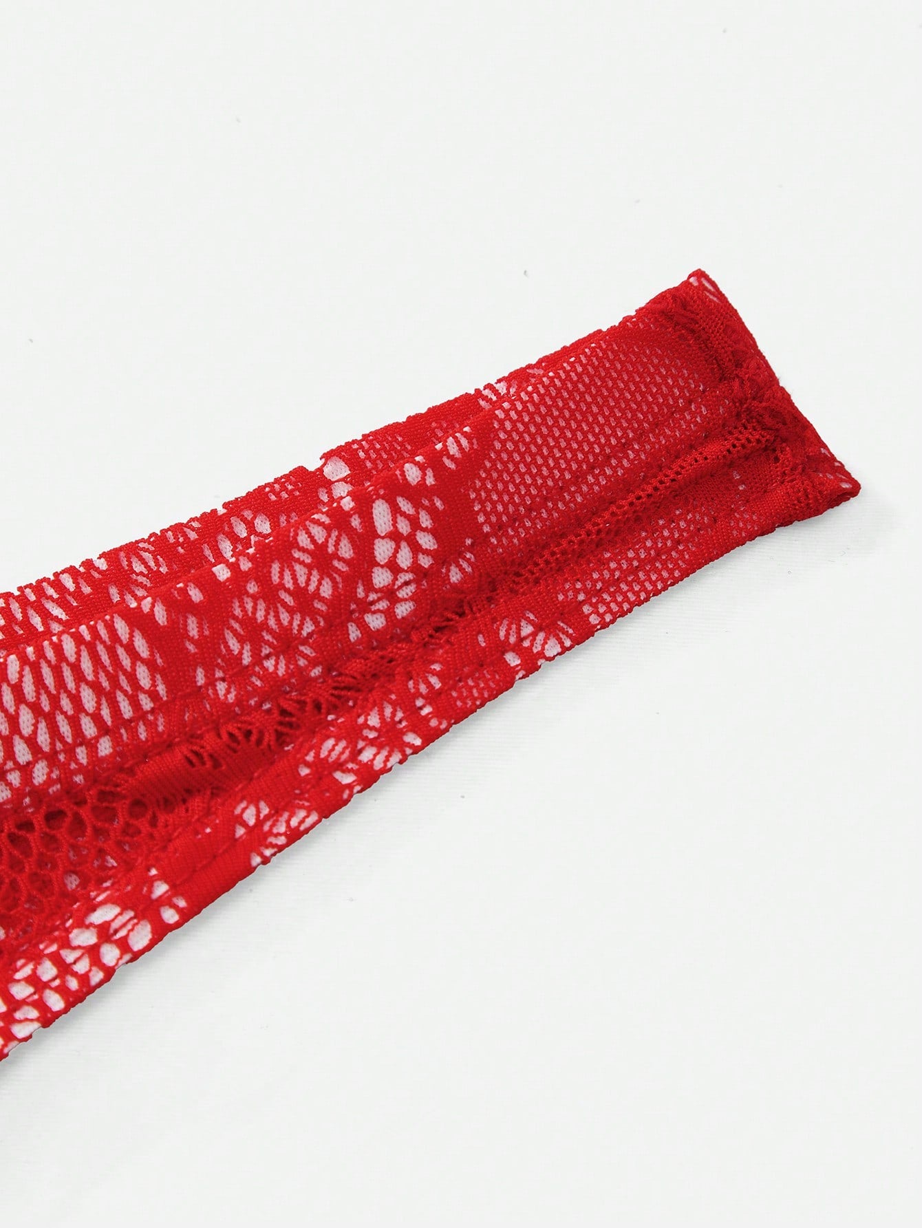 Red lace semi-sheer thong panty with hollow out detail and low rise design, made from stretchy polyamide and elastane blend.