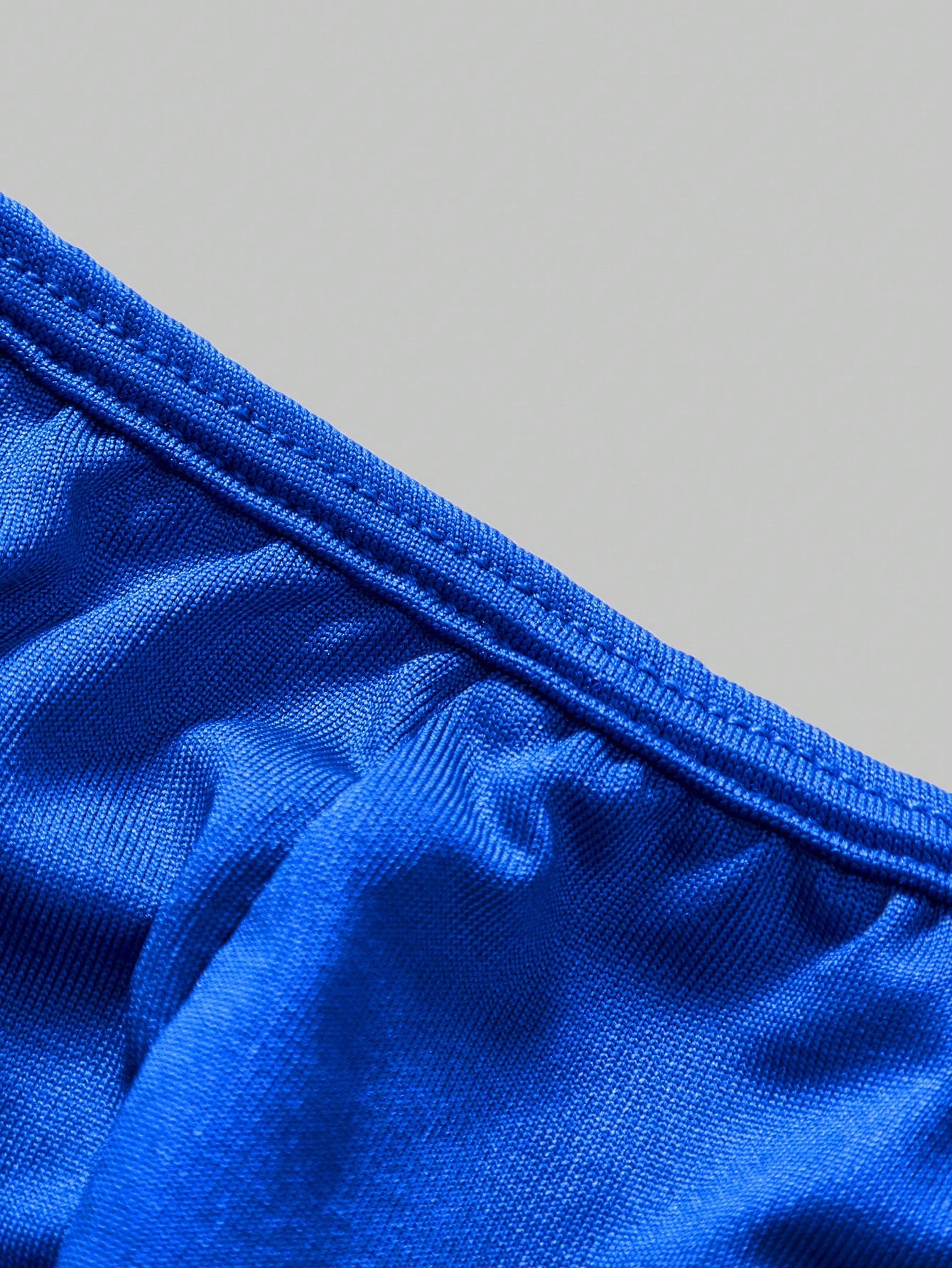 Men's low-rise thong underwear with metal chain detail, colorblock design, and high-stretch knitted fabric in a V-string style.