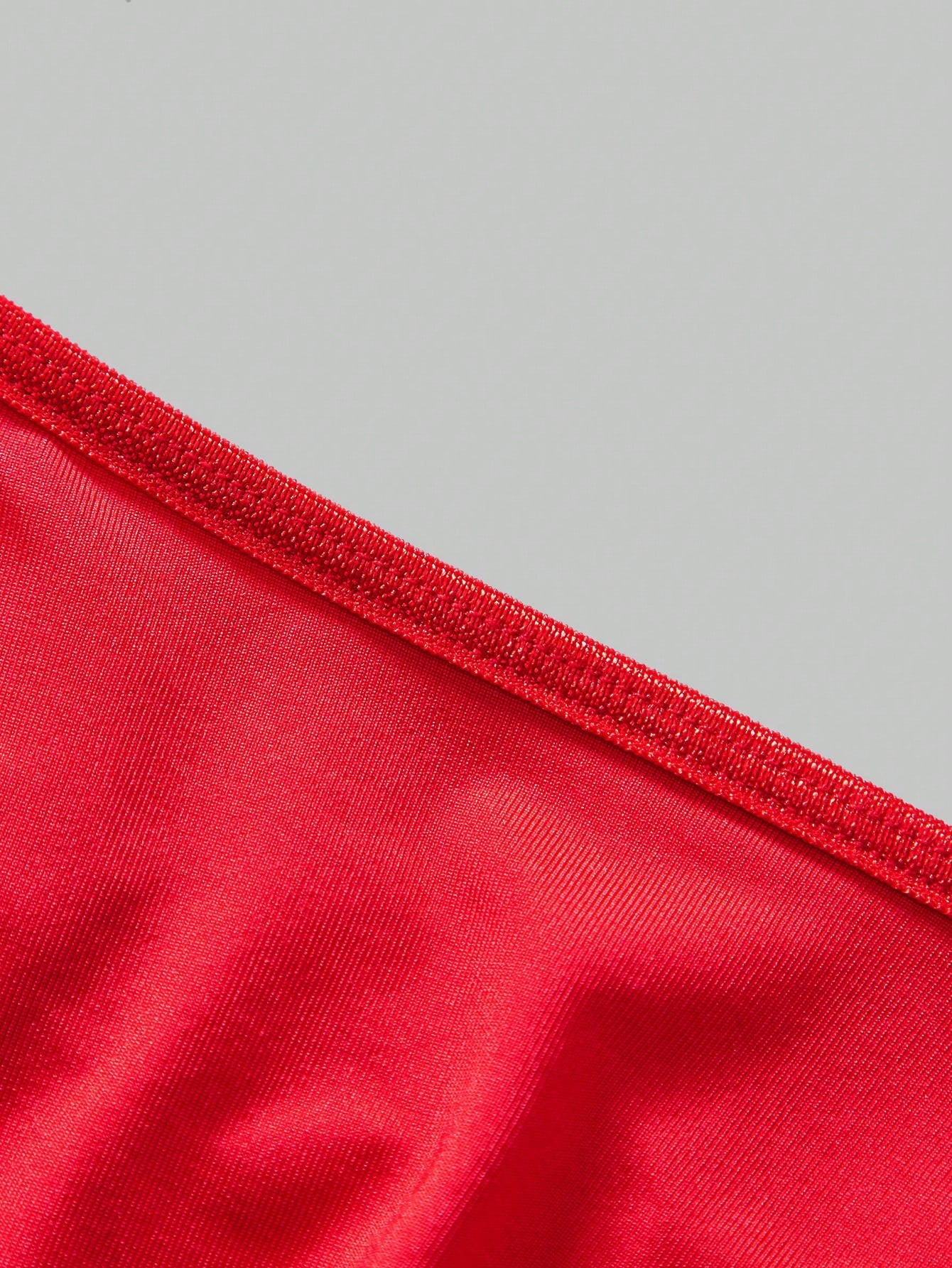 Men's red low rise thong briefs with chain decor, plain knitted fabric, high stretch polyester spandex blend, unlined and non-sheer.